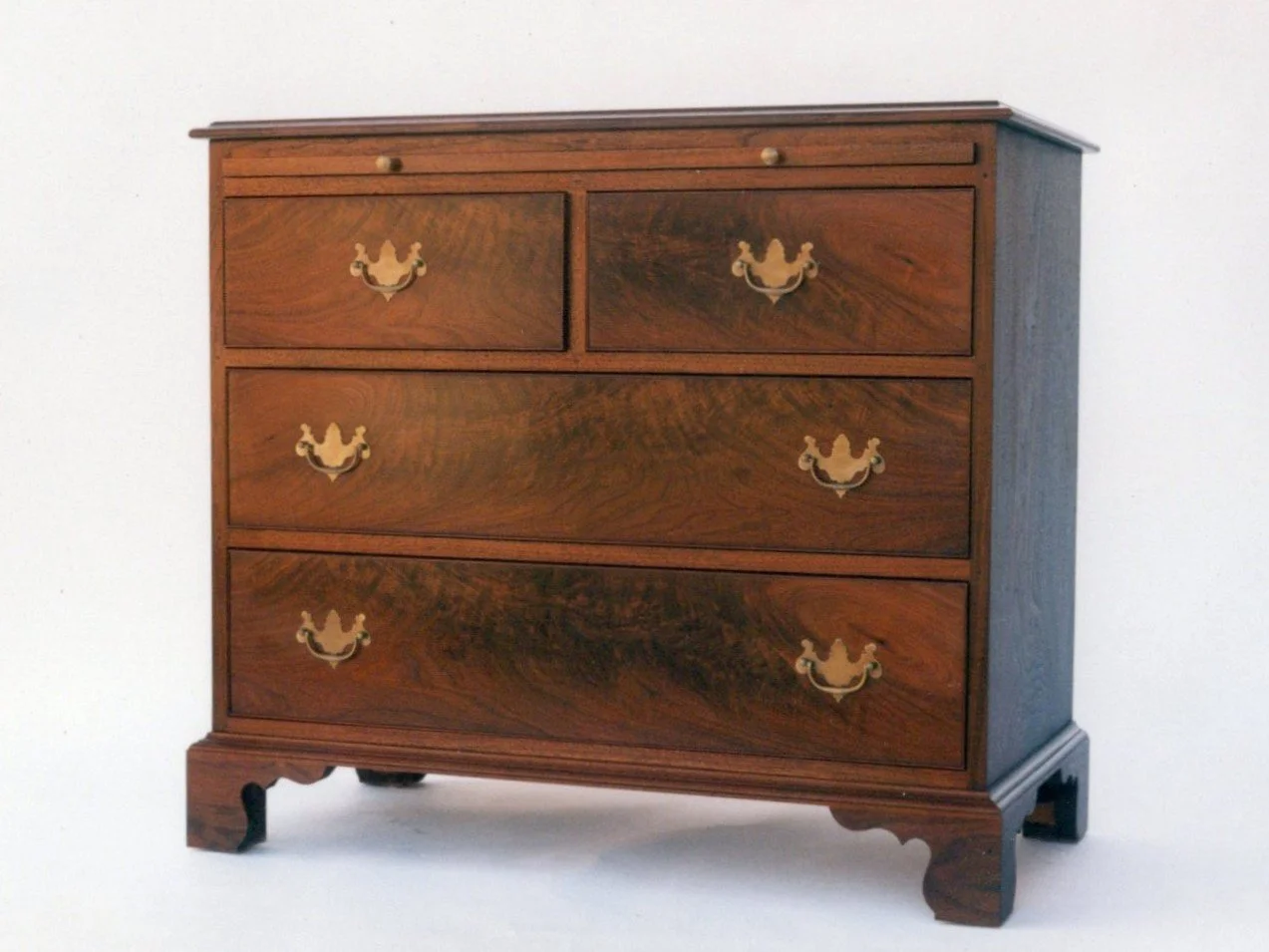 Hand crafted bachelors chest with brushing slide in walnut and crotch walnut.