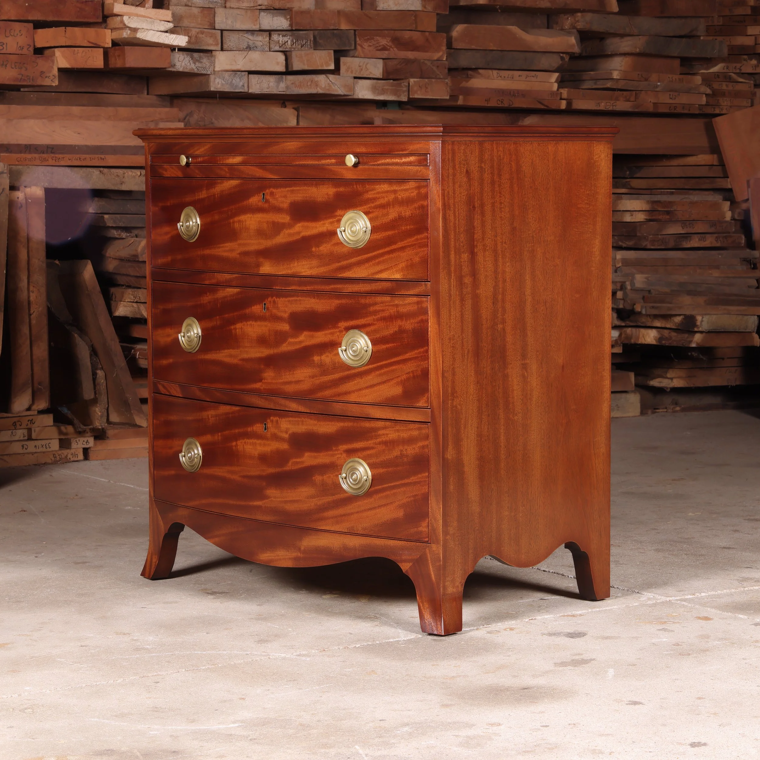 Handcrafted English Style Bow Front Chest with Brushing Slide in figured mahogany.