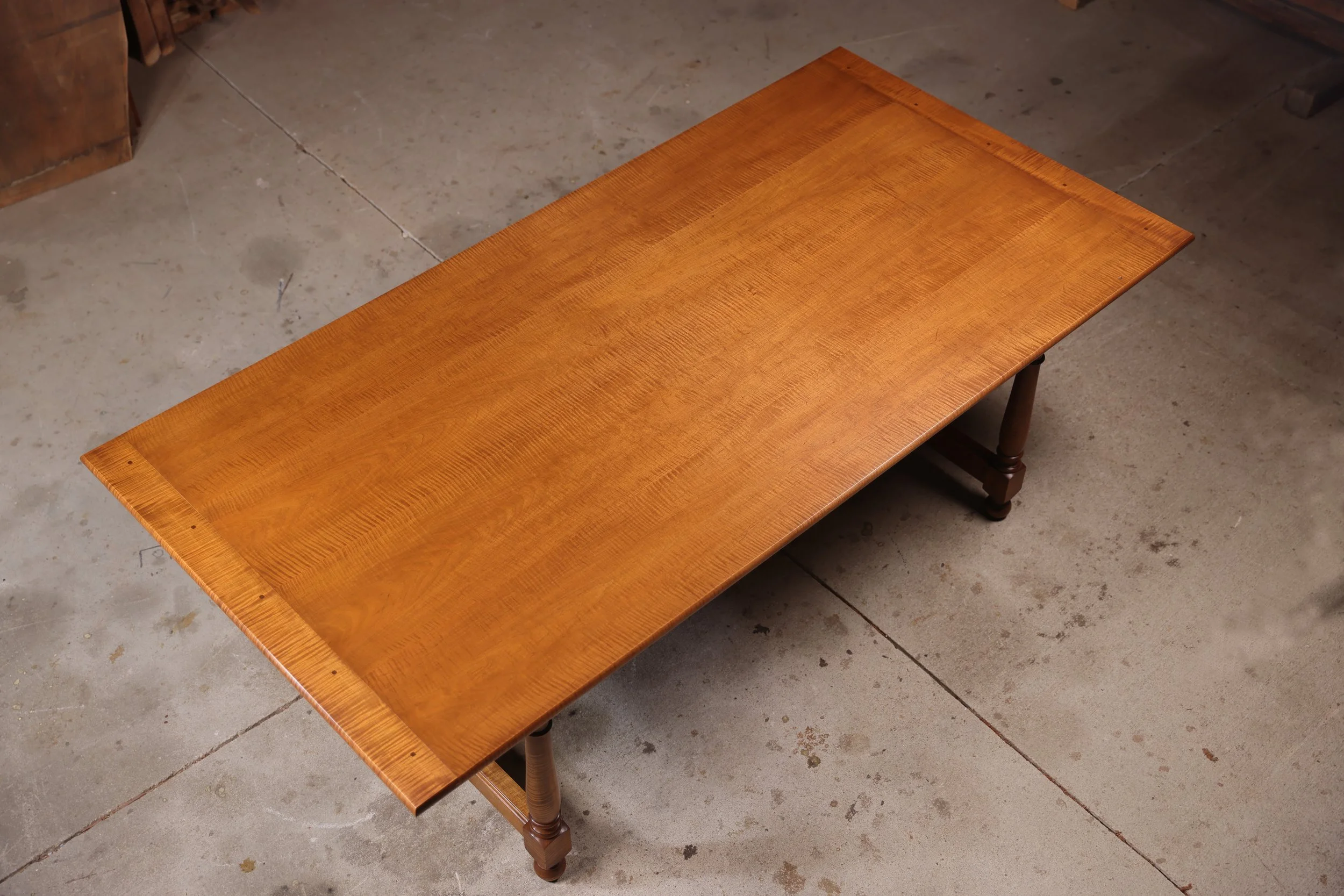 Handmade maple dining room table showing a matched four board top with draw pegged breadboard ends.