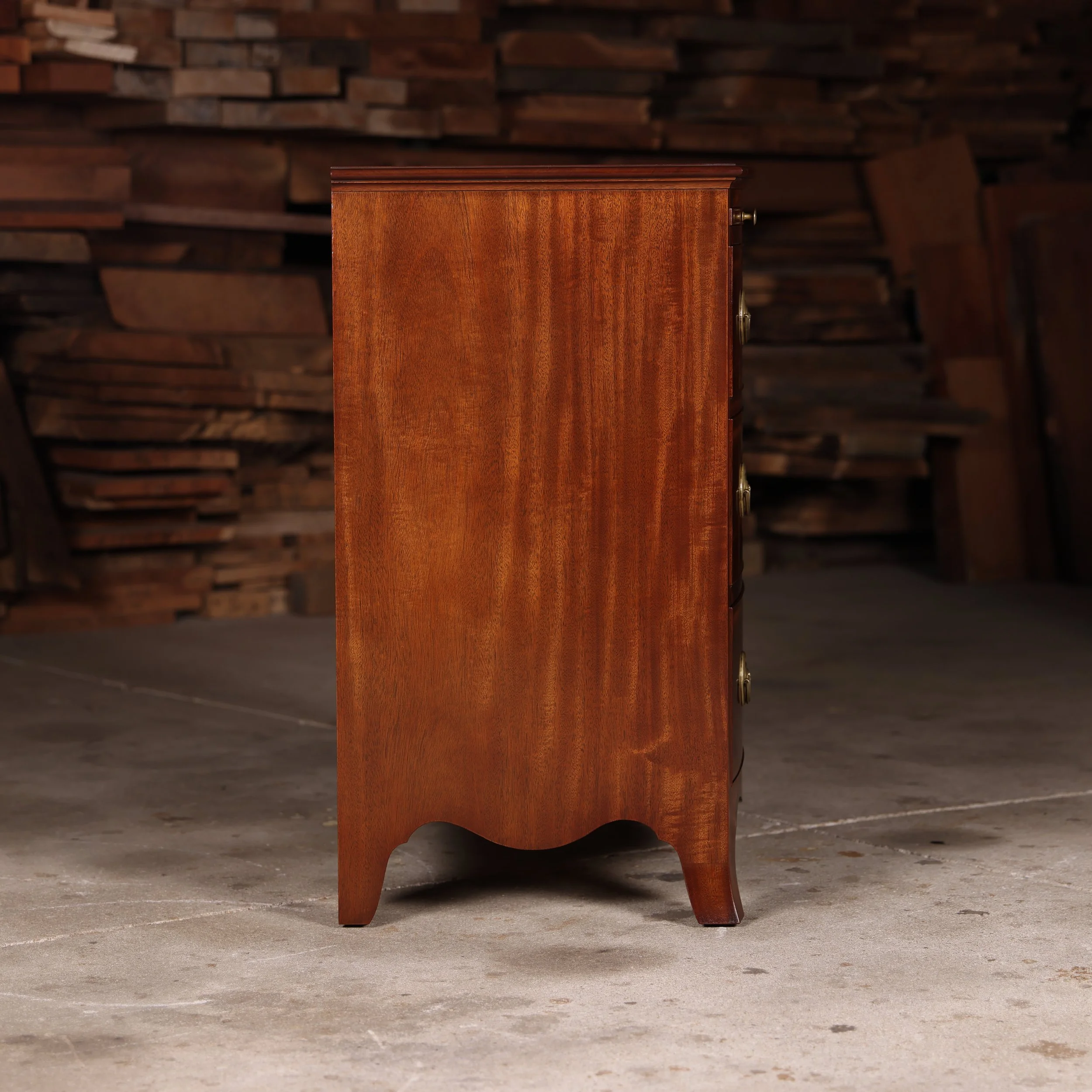 Handmade bow front chest, right side view. Single wide mahogany case side.