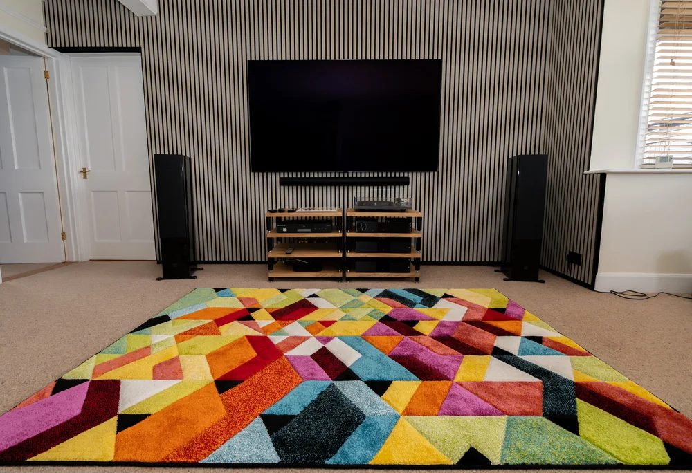 Grey oak acoustic slat media wall with a large television in a Storrington living room