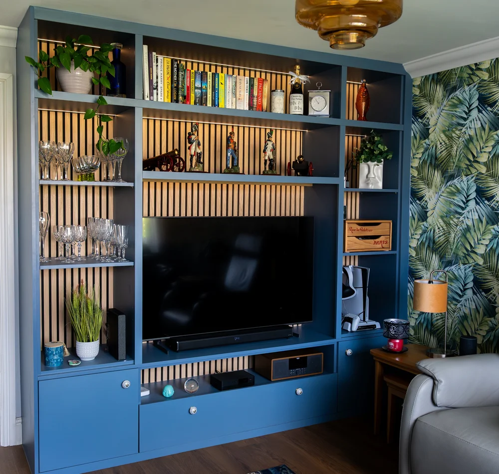 Misty blue media wall with oak panelling, open shelves and a television in Lancing