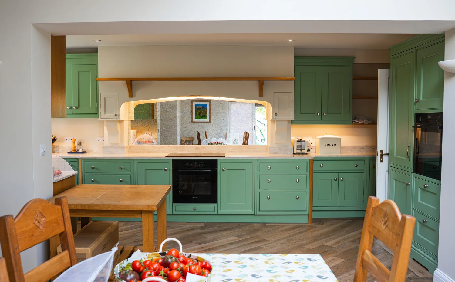 Painted green in-frame kitchen seen from the dining table, Steyning