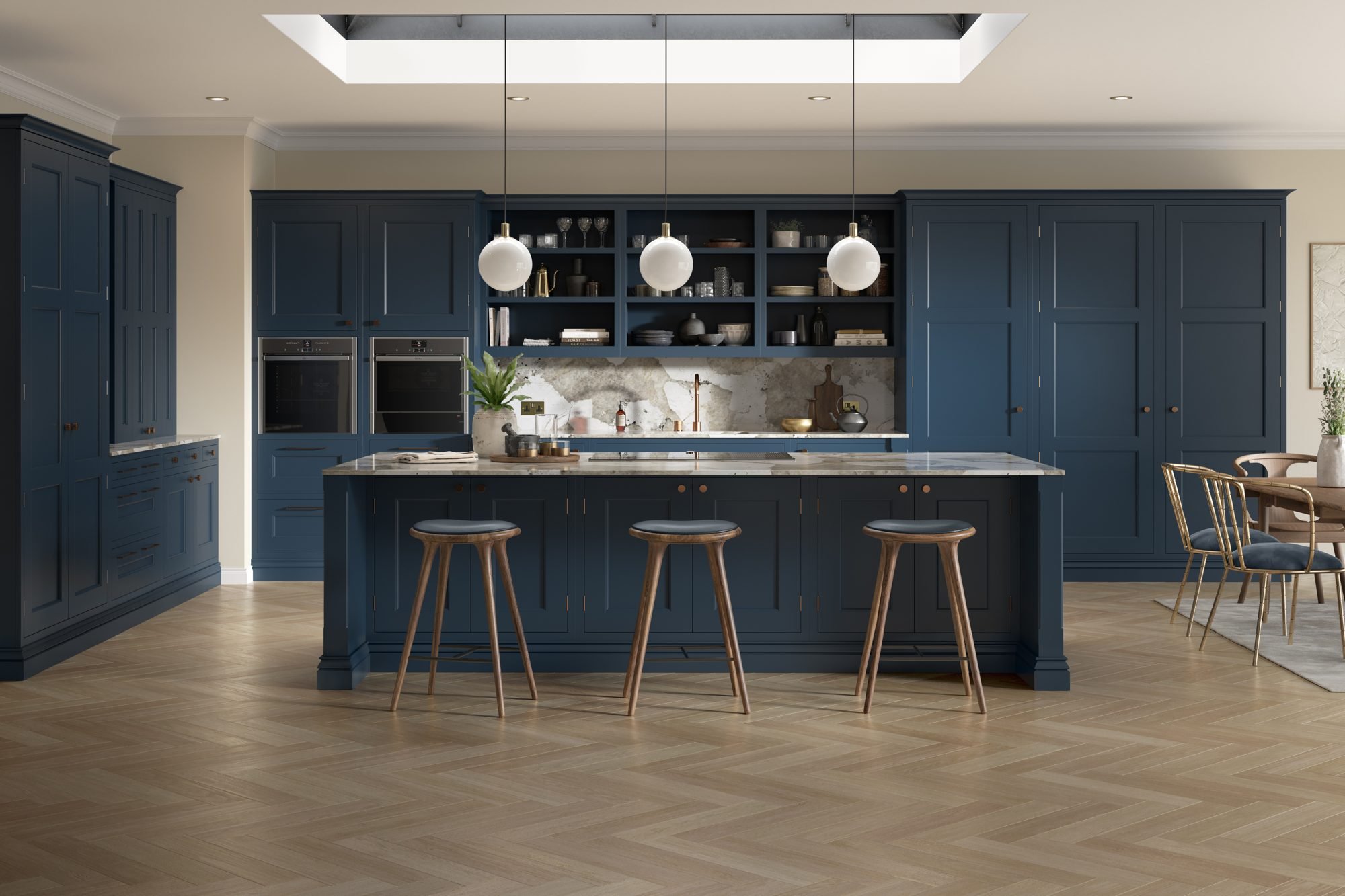 Navy kitchen island with three wooden stools in front of a wall of tall navy units and open shelving