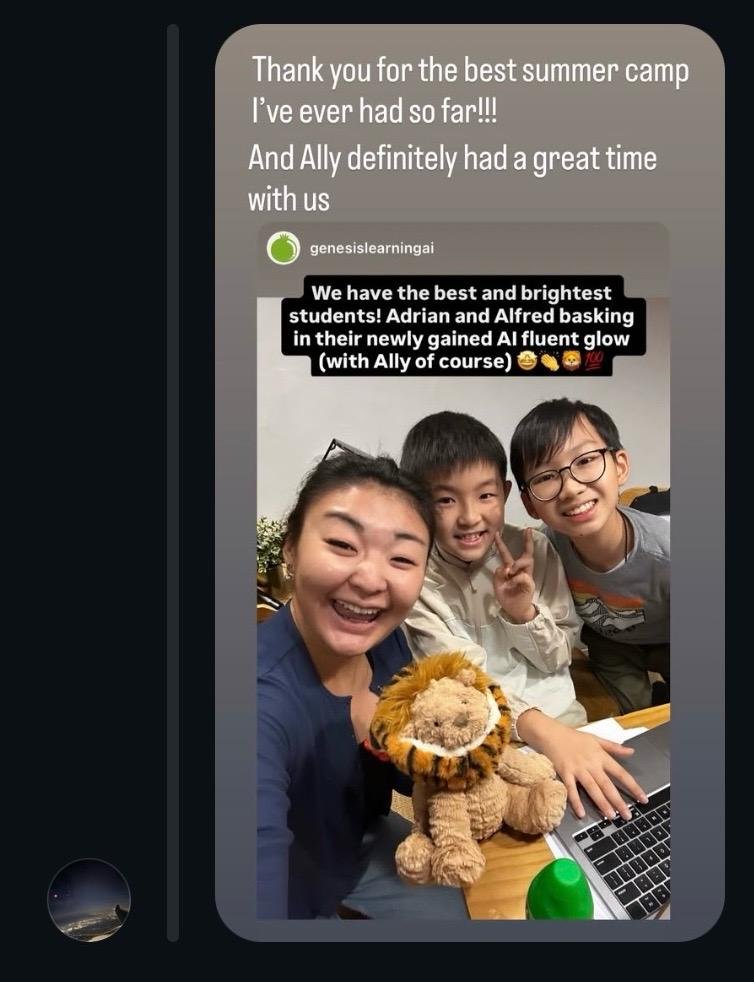 Three children smiling at a camera, with a plush lion toy and a laptop on a table, in a classroom or office setting.