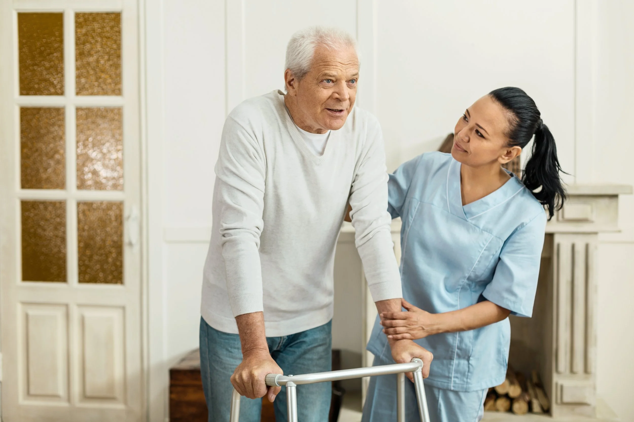 physiotherapist teaching elderly man with walking difficulties how to use a walker