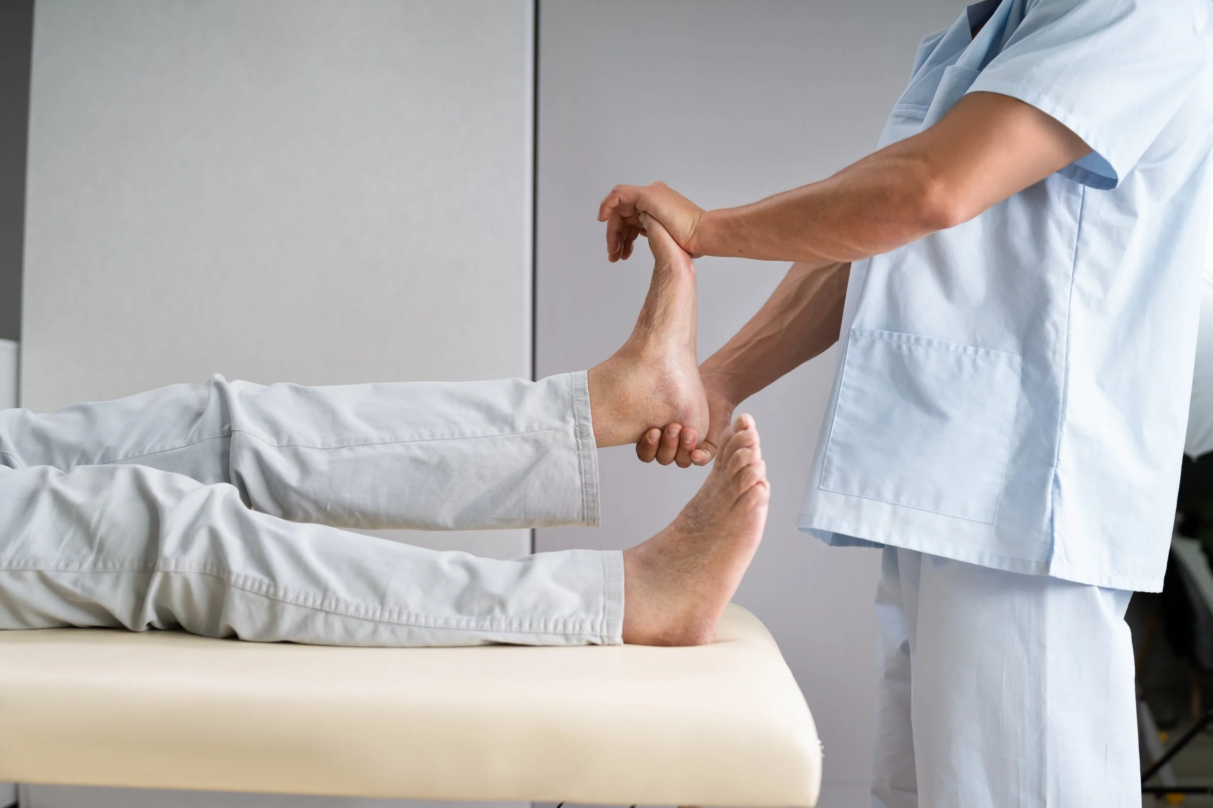 Physiotherapist providing physical therapy for patient with ankle sprain or strain