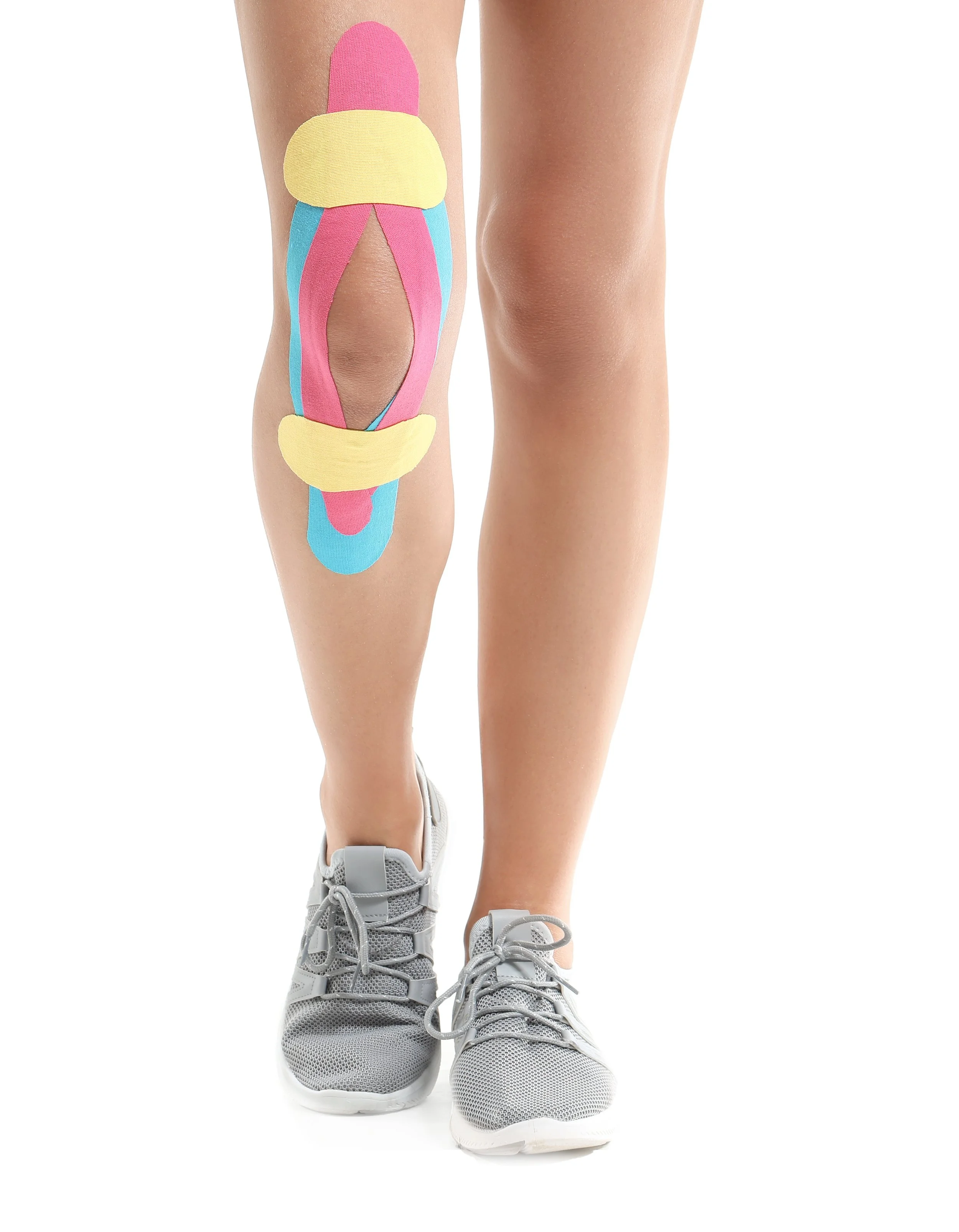 Sporty woman with ACL tear with physio tape applied on knee against white background