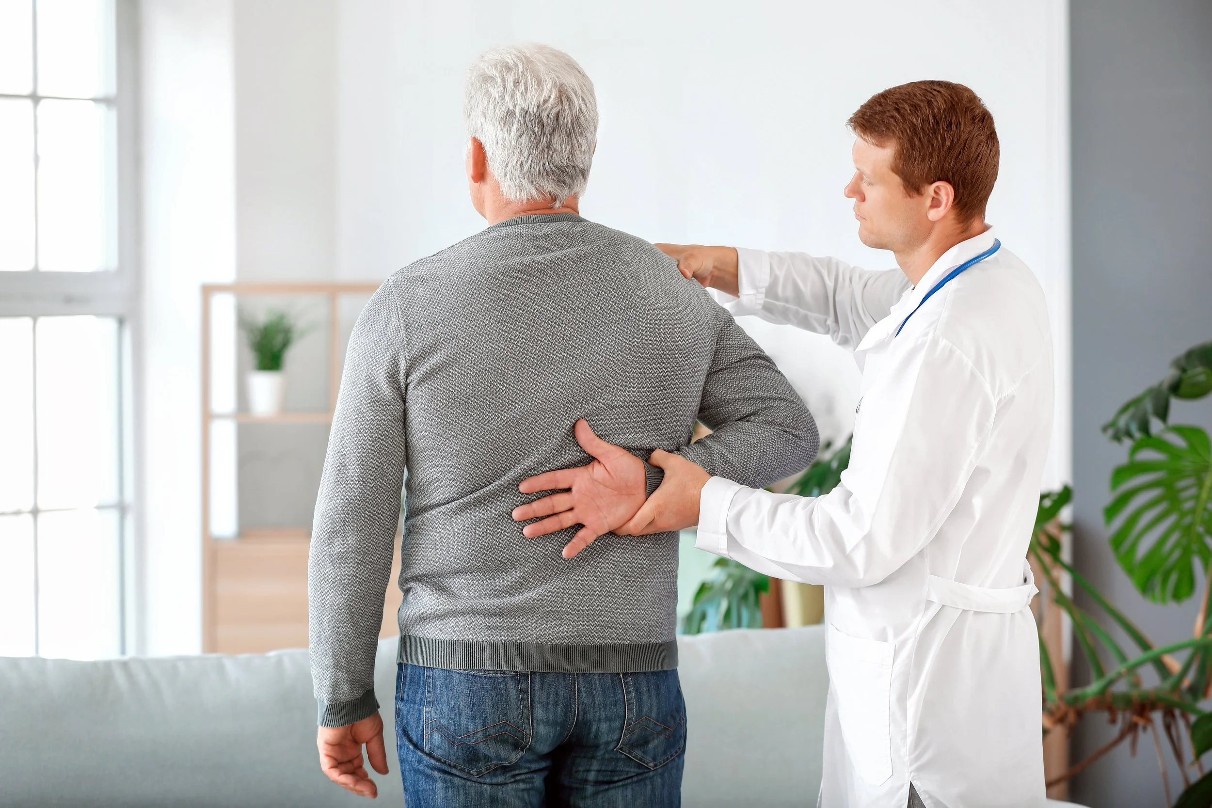 physiotherapist examining man with shoulder sprain