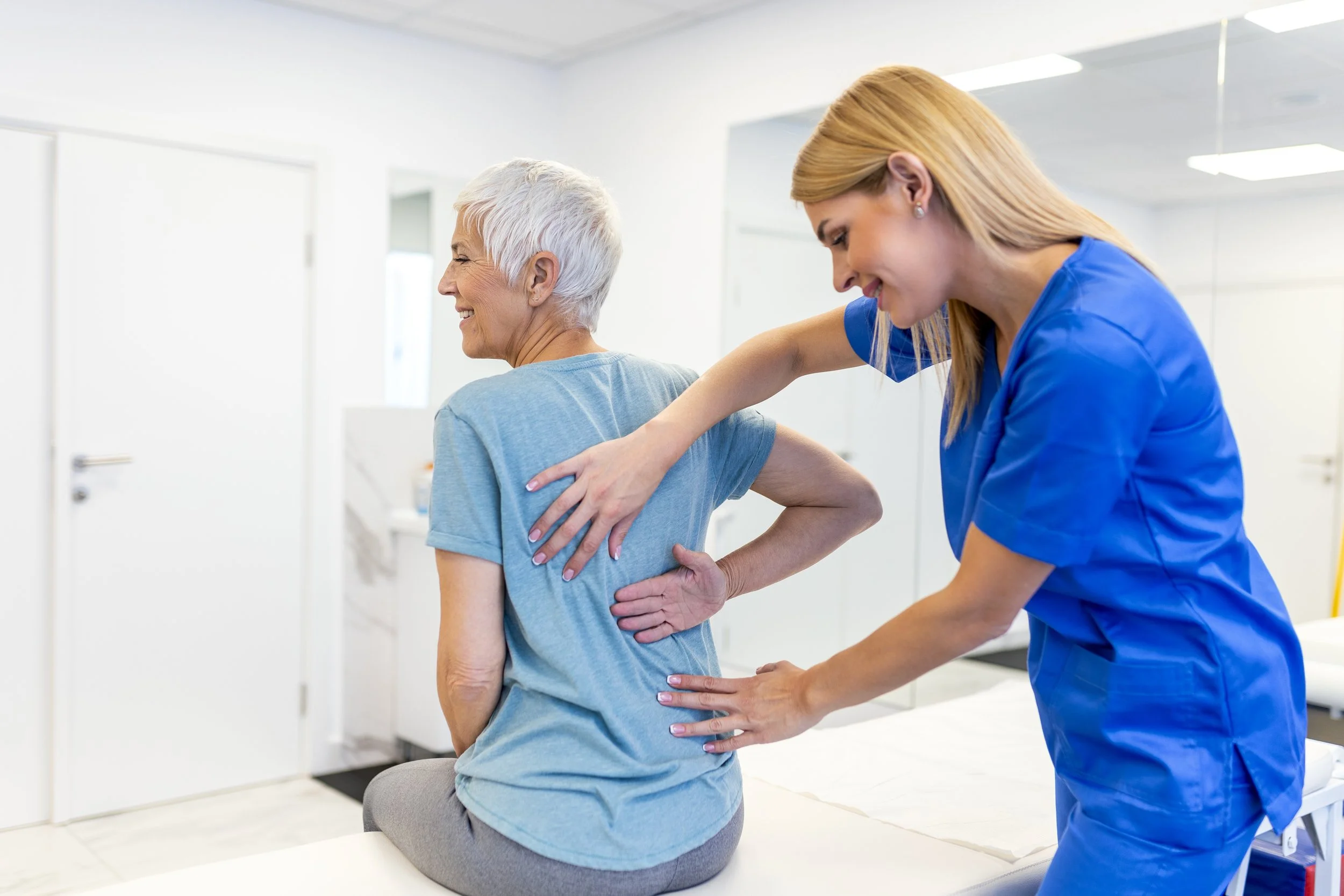 Elderly woman receiving physical therapy for herniated bulging disc from physiotherapist;Scoliosis Spine Curve Anatomy, Posture Correction. Chiropractic treatment, Back pain relief.