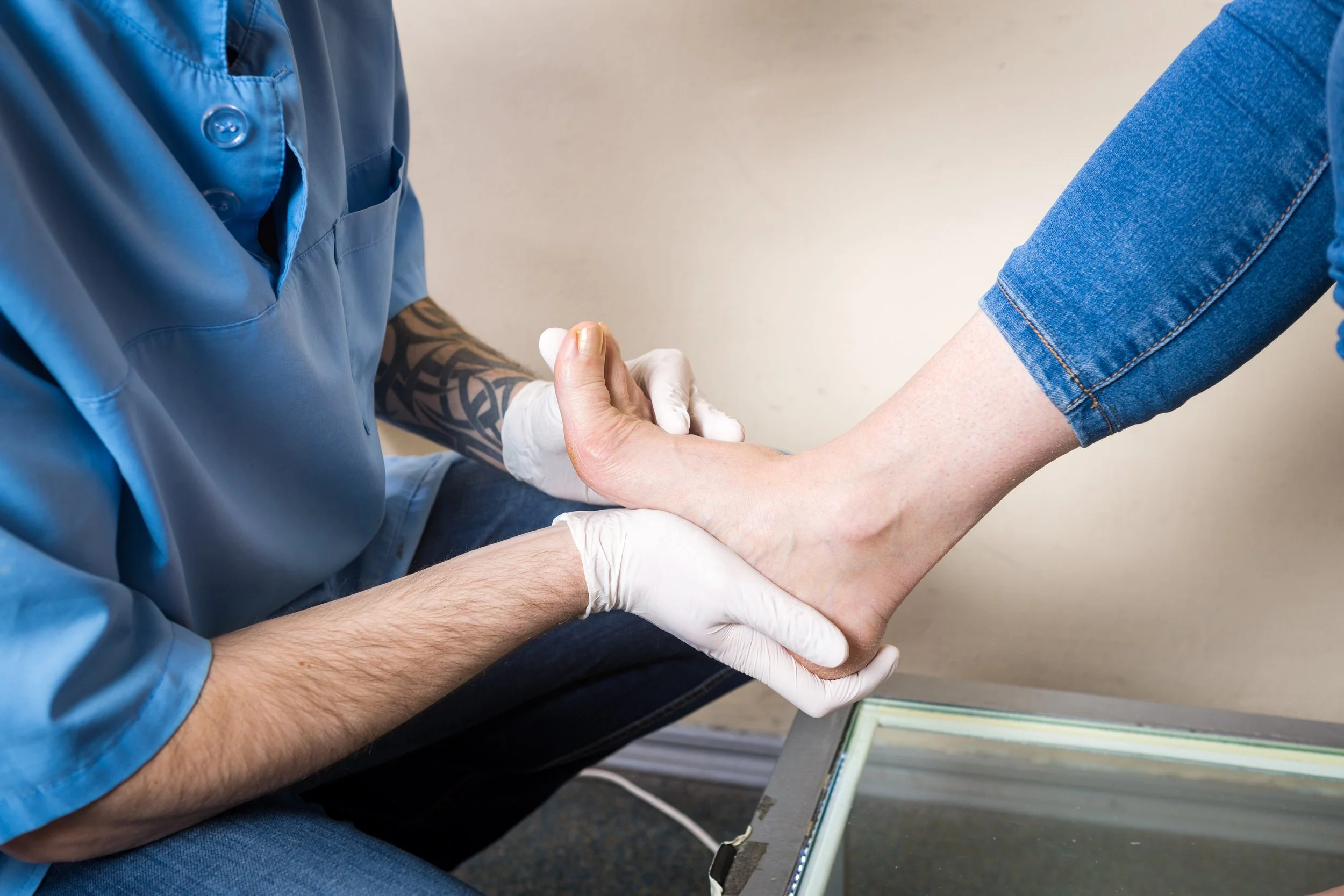 male physiotherapist conducts diagnostics, foot test of a woman for post foot ankle surgery rehabilitation
