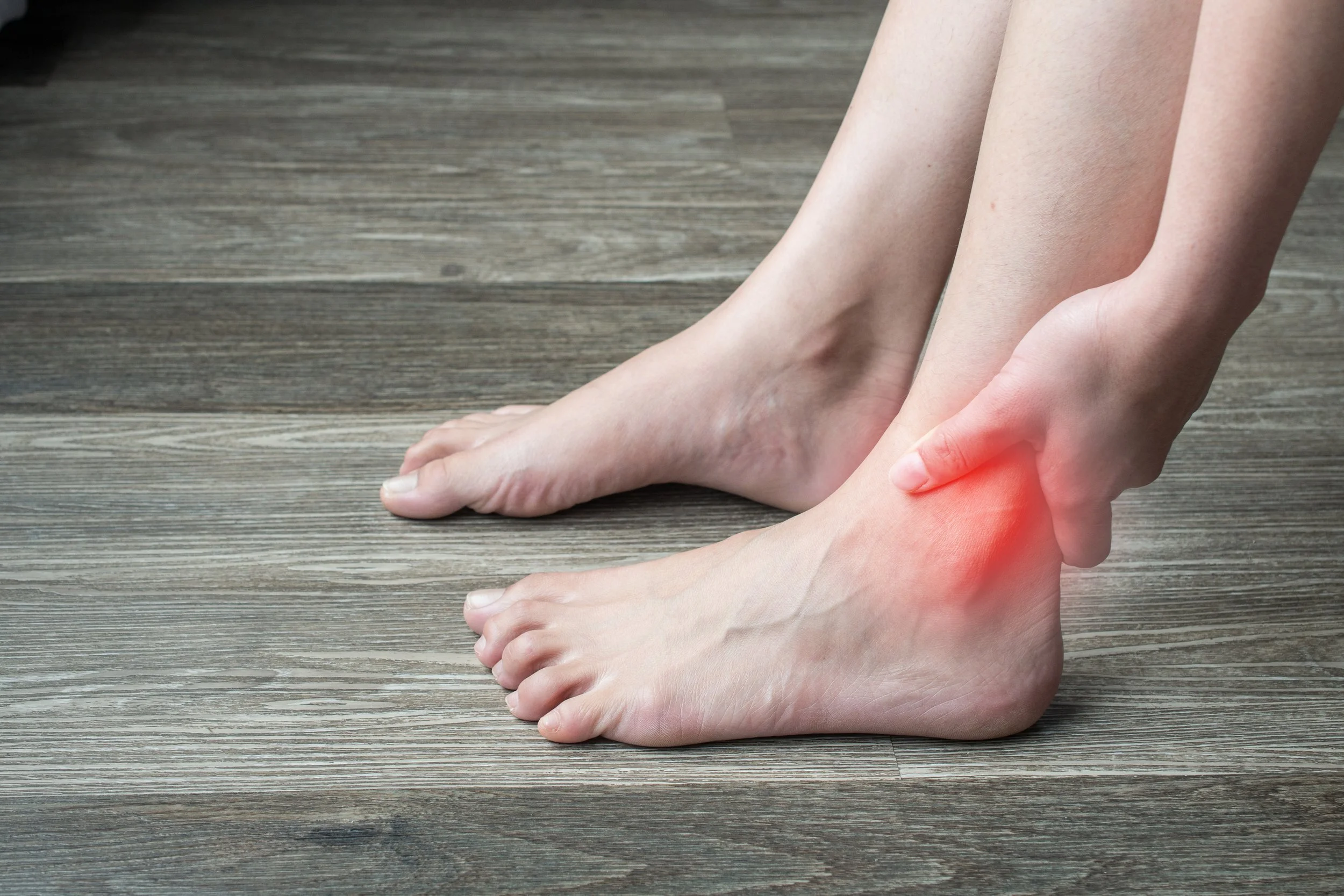 Woman hands touching her ankle, suffering from ankle and foot pain from fracture