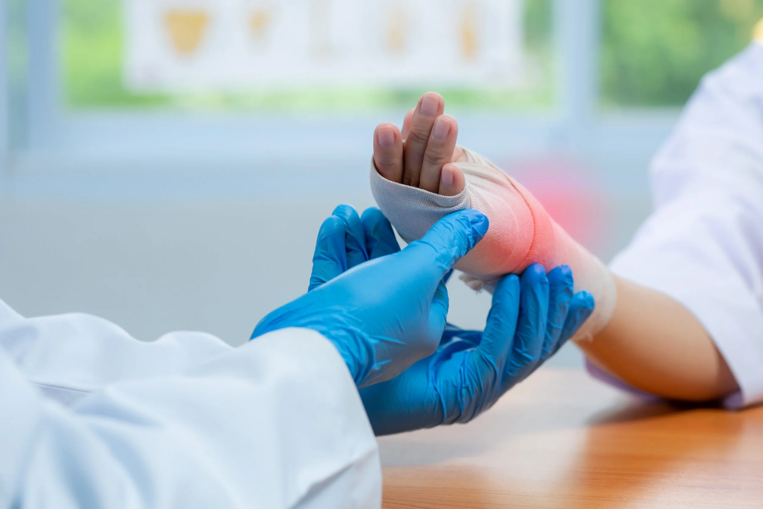 Orthopedic doctor wear medical gloves Of Doctor Hand Tying Bandage On The wrist inflammation Of Patient In Clinic