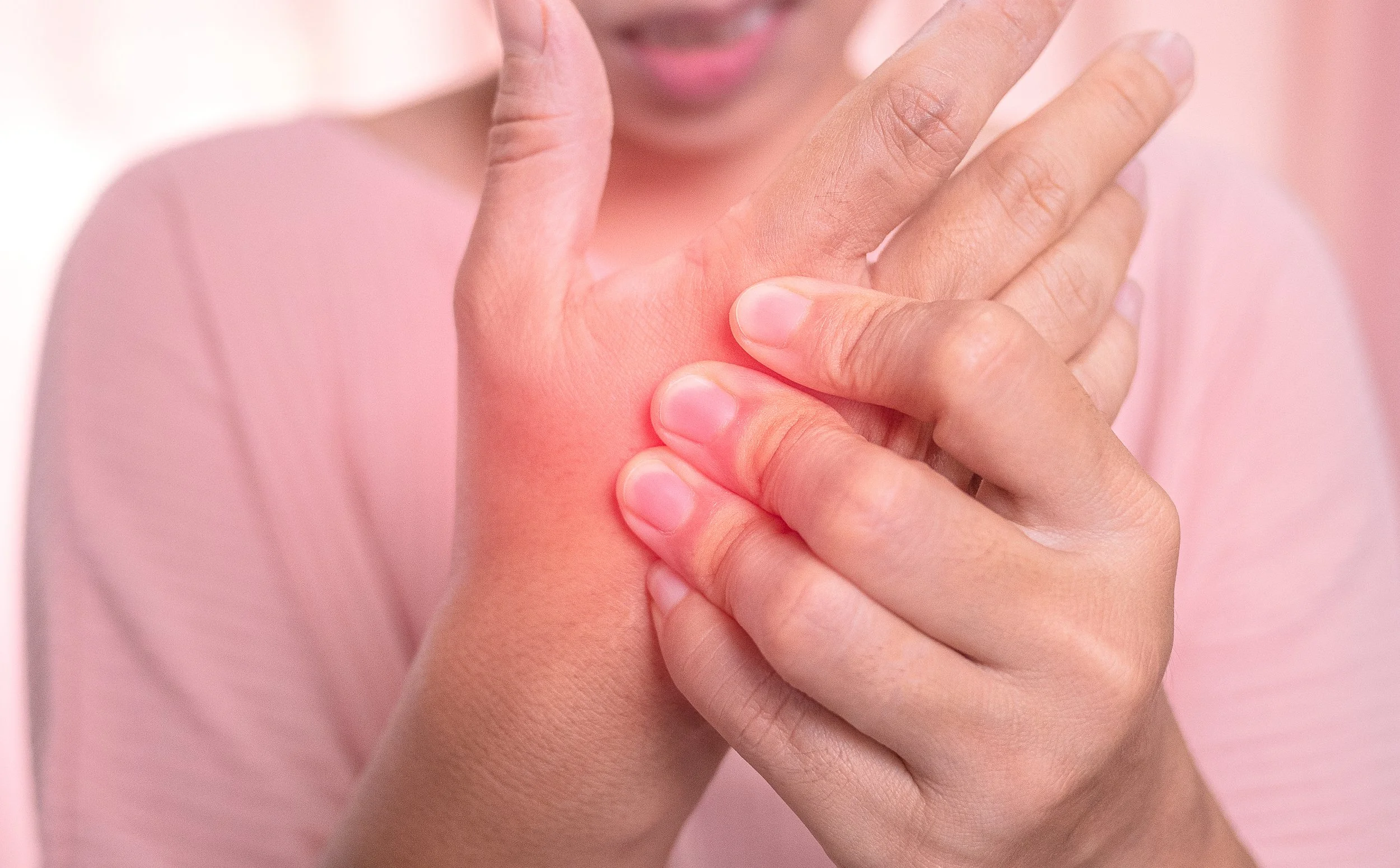 Person experiencing nerve injury pain touching hand.