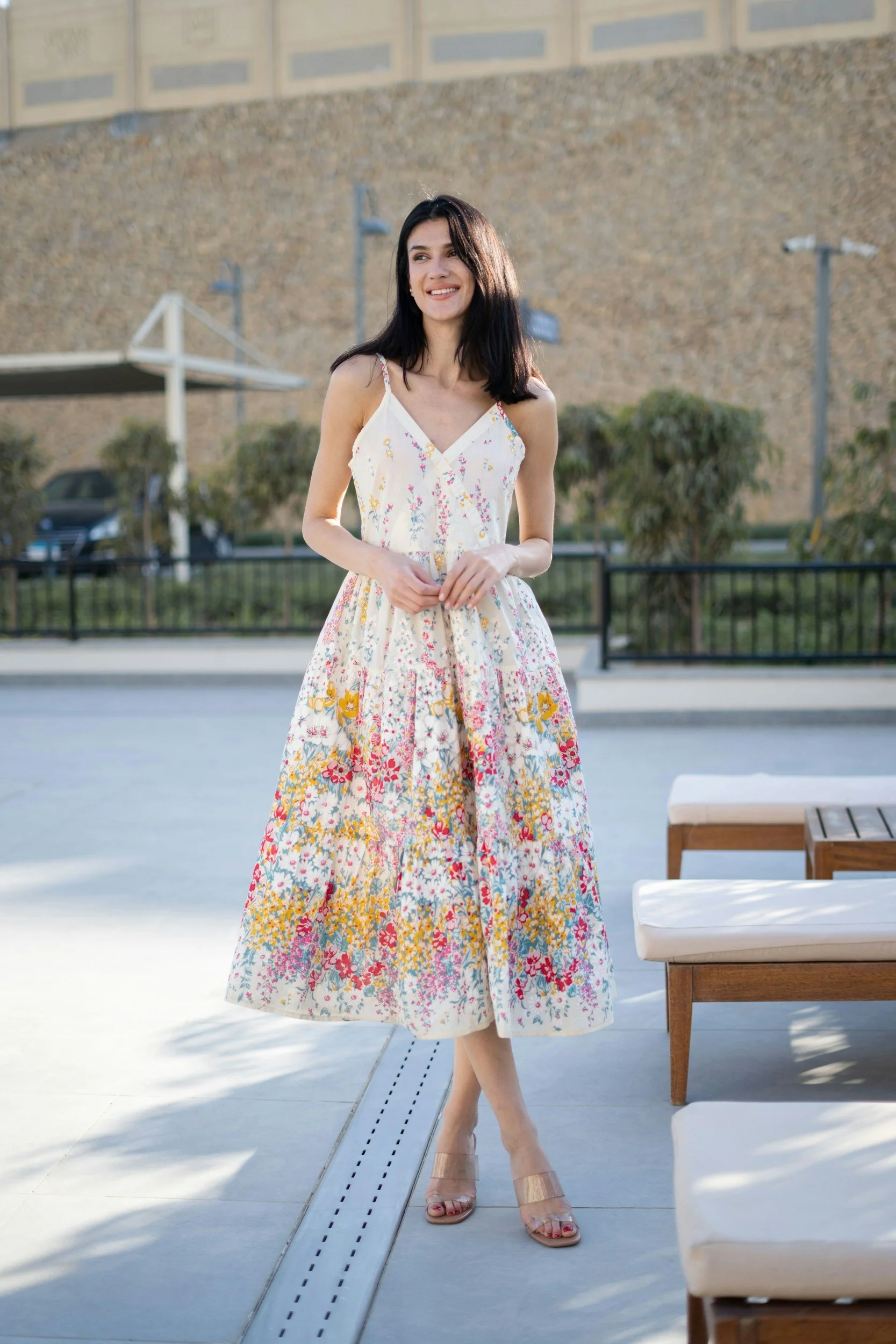 Woman wearing a sleeveless floral summer dress standing outdoors, representing the Women’s Dresses section on the Aglo Designs merchandise page.