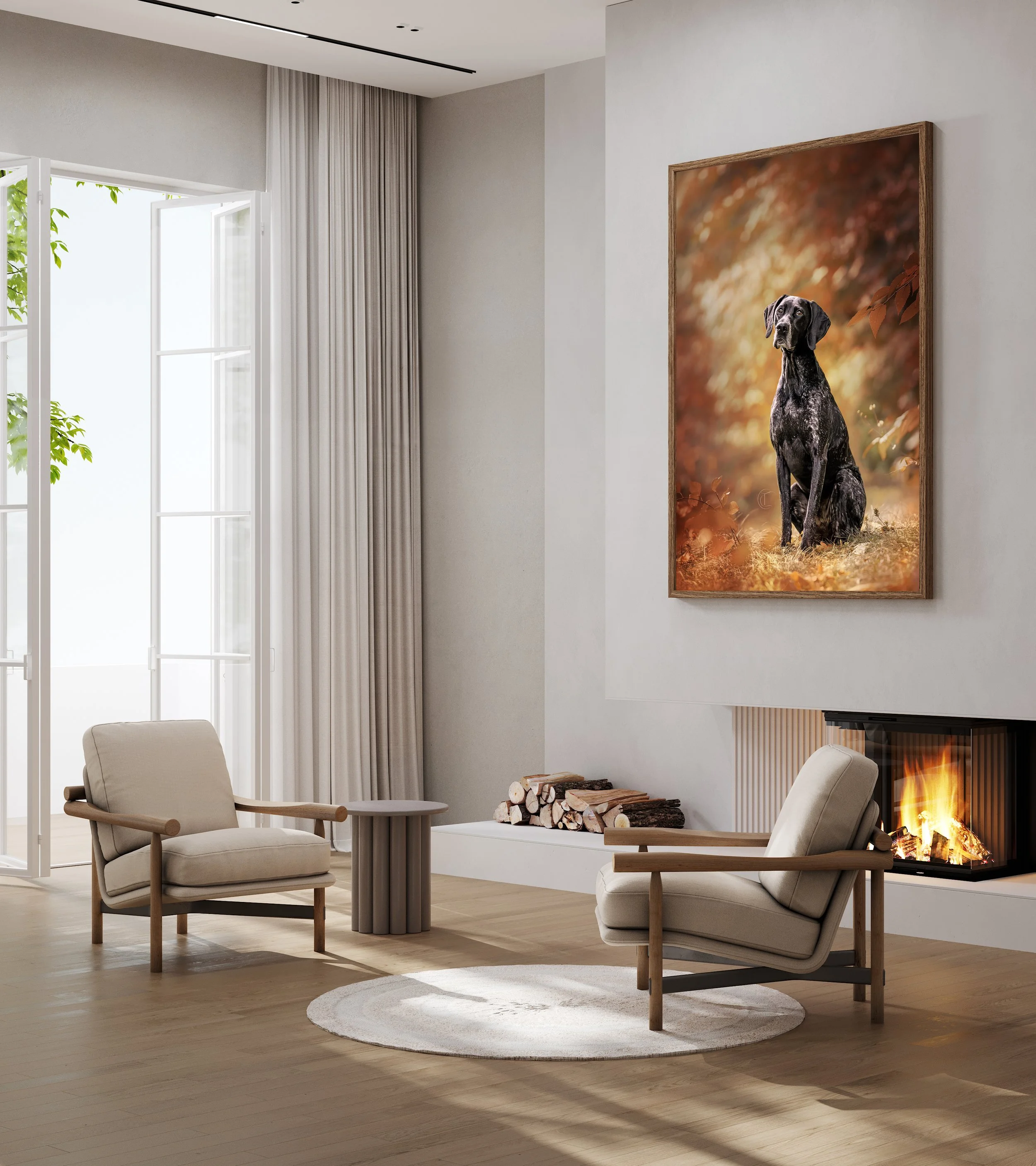 Modern living room with white walls, large windows with sheer curtains, a beige armchair, a round side table, a fireplace with a fire, a stack of firewood, and a large framed photograph of a black dog in a fall outdoor setting.