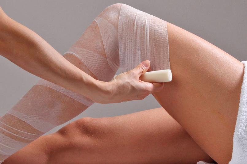 Persona che avvolge una gamba con una benda elastica