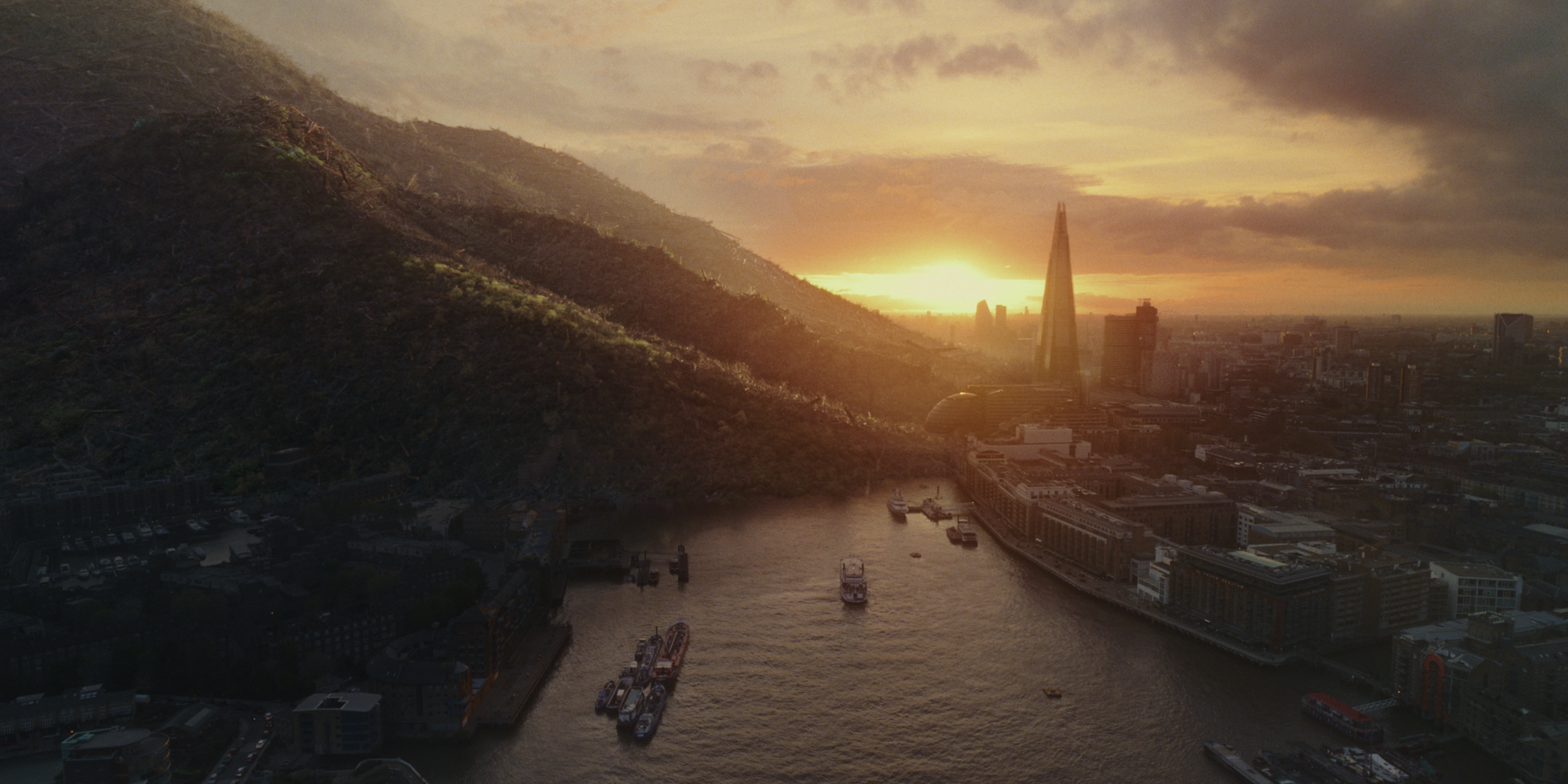 Storm Elfrink - Canopy - Pack4Good - A city skyline at sunset with a river in the foreground and a green hill on the left side.