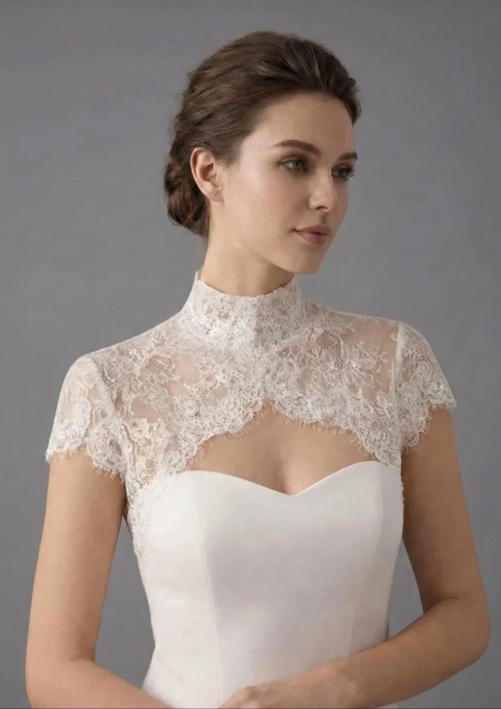 Bride wearing a short-sleeve lace bridal topper with a high neckline and keyhole front over a sweetheart wedding gown
