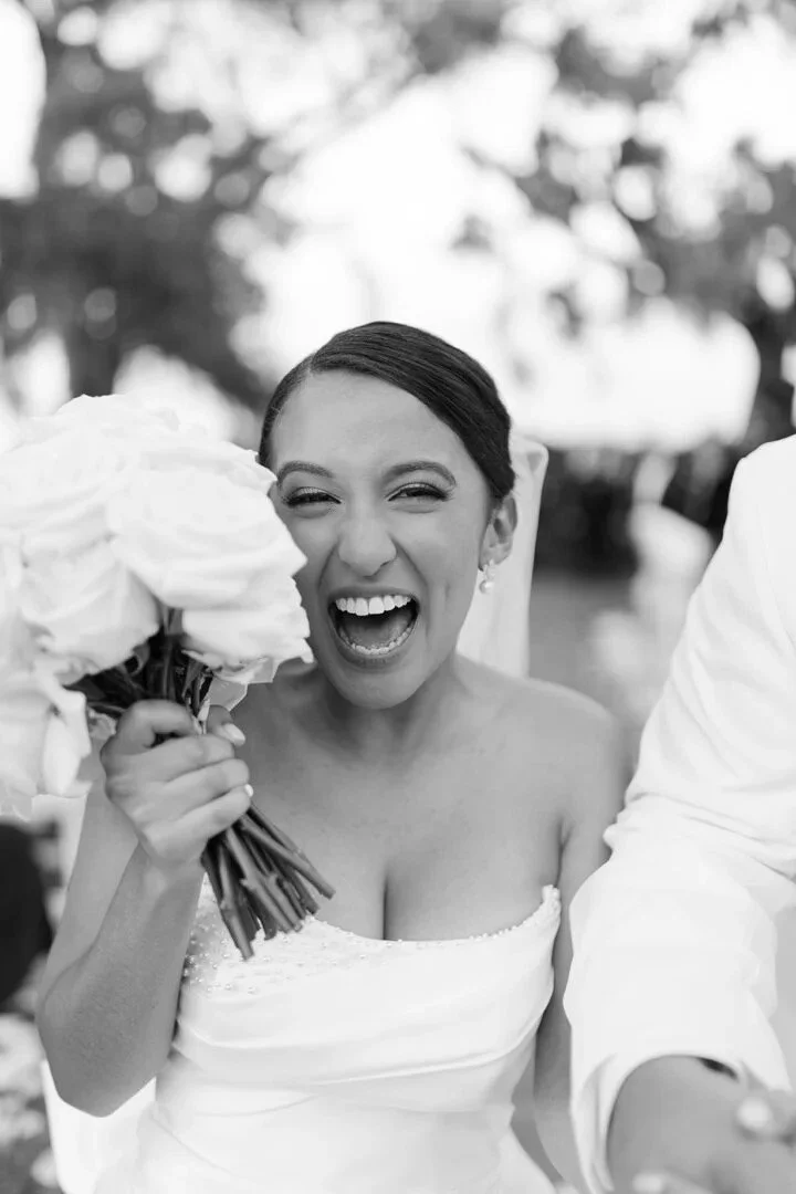 Joyful Sira D’ Pion bride holding a floral bouquet in a custom strapless wedding gown