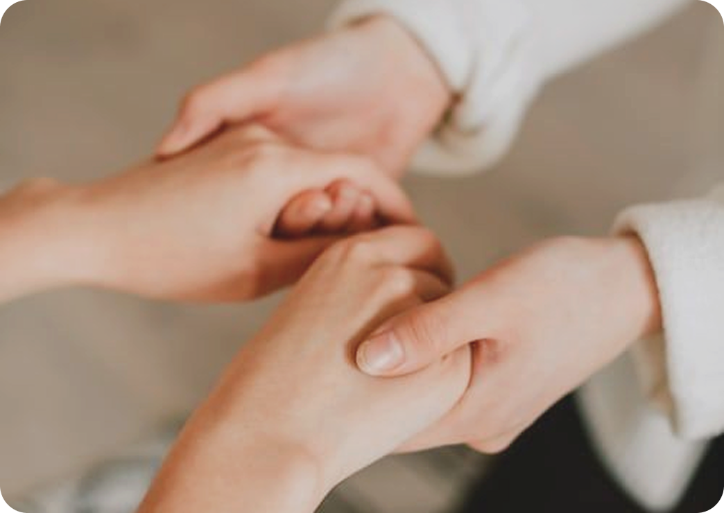 Dos personas sujetándose de las manos en señal de apoyo o amistad.