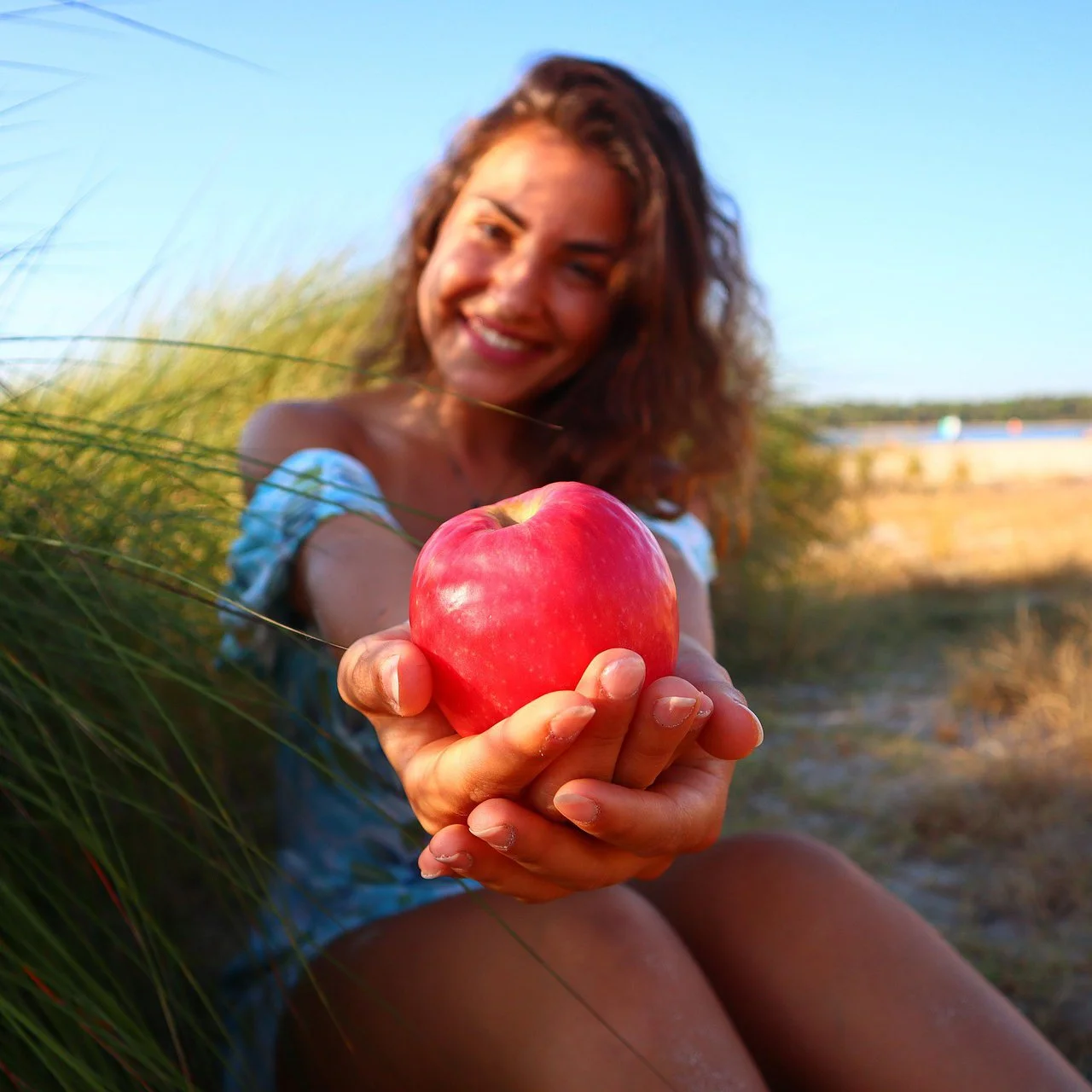 A woman offers you an apple to help you stick to your new year's resolution.