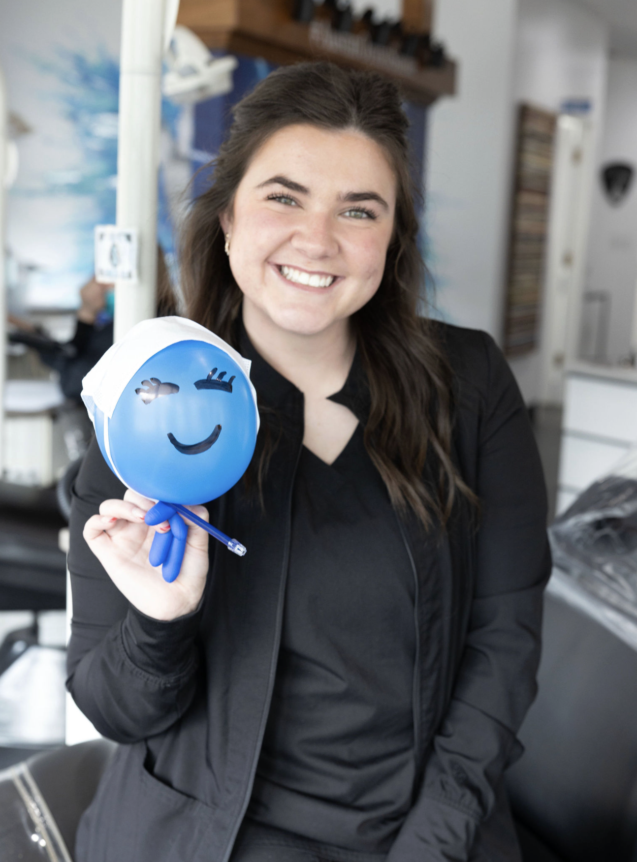 Dental Assistant holding balloon with a smily face on it