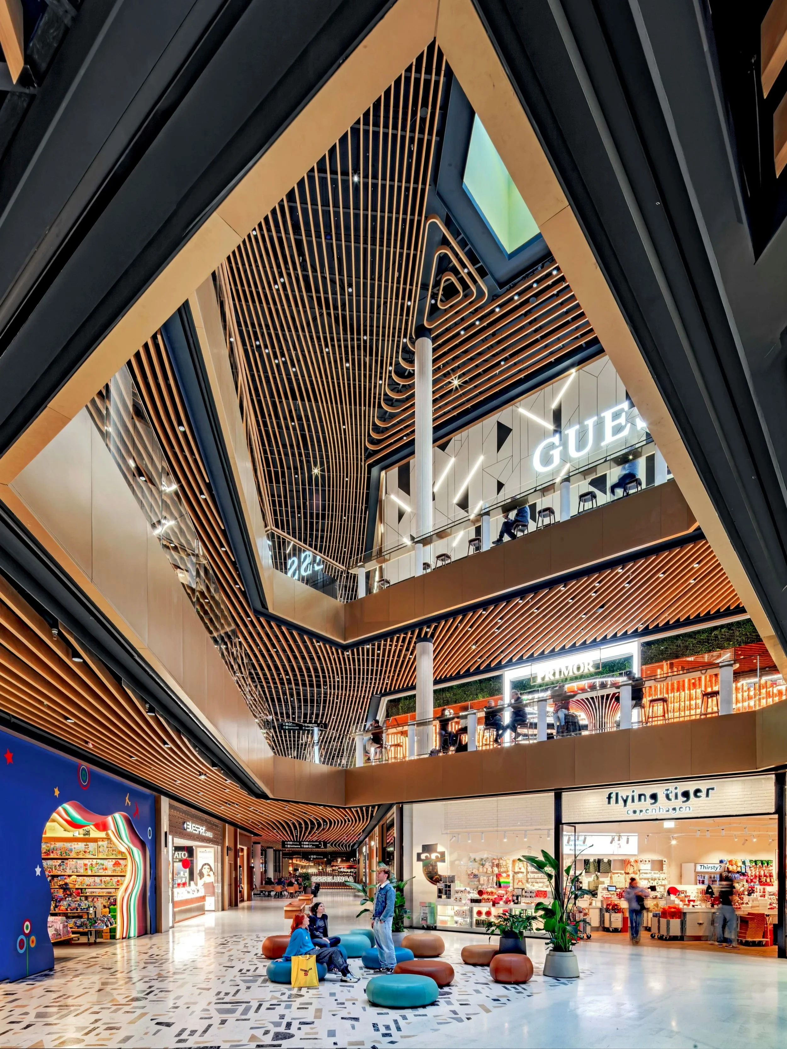 Shopping mall interior with tall ceilings and wooden patterns.