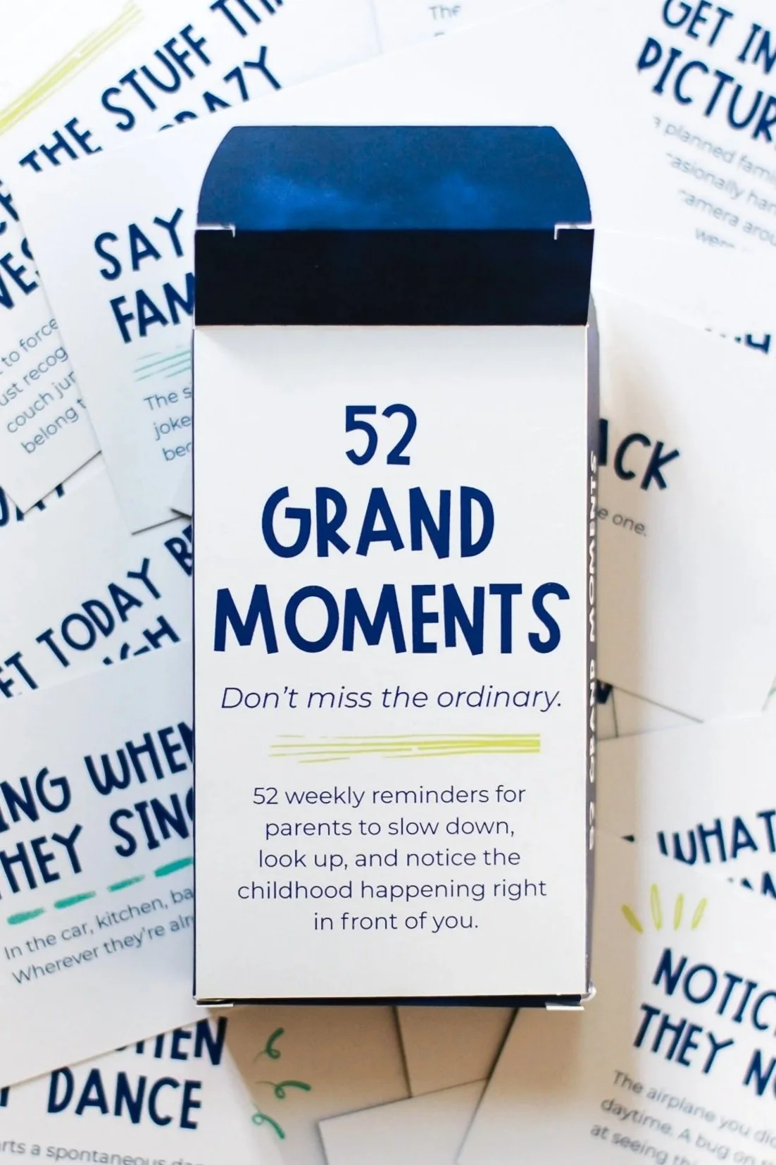 52 Grand Moments card deck surrounded by scattered cards with reminders for parents to slow down, notice, and connect with their kids.
