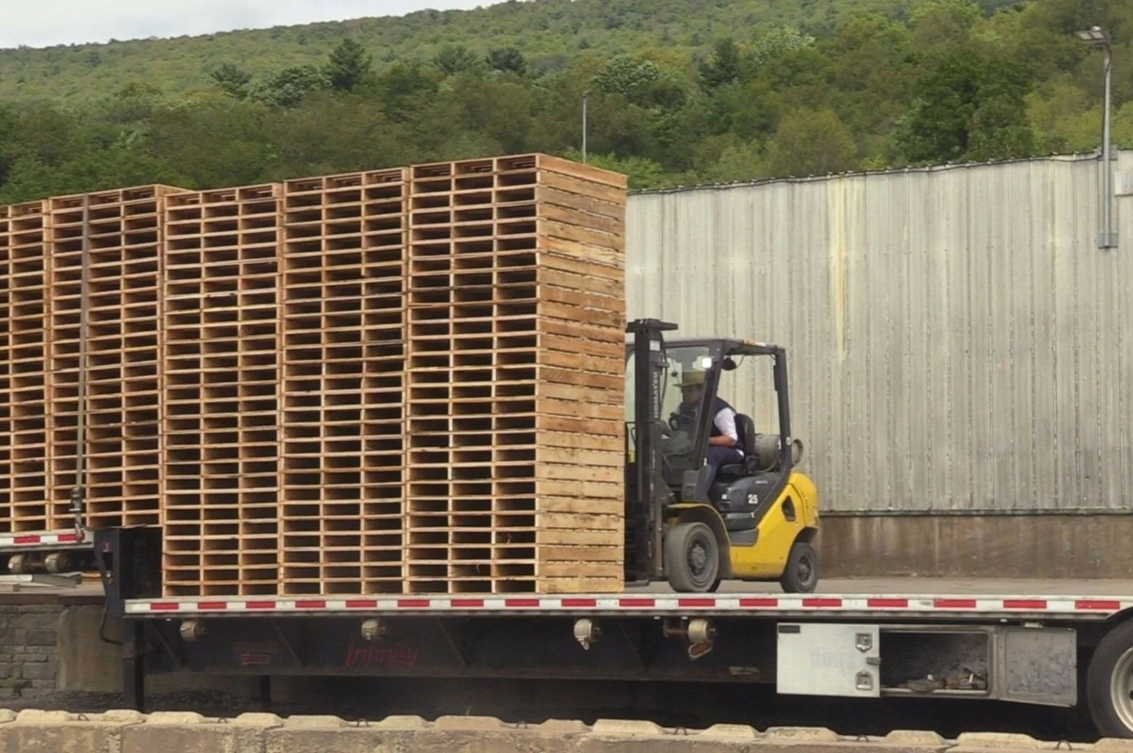 Forklift loading a trailer with quality wood pallets at Bridger Creek LLC in central Pennsylvania