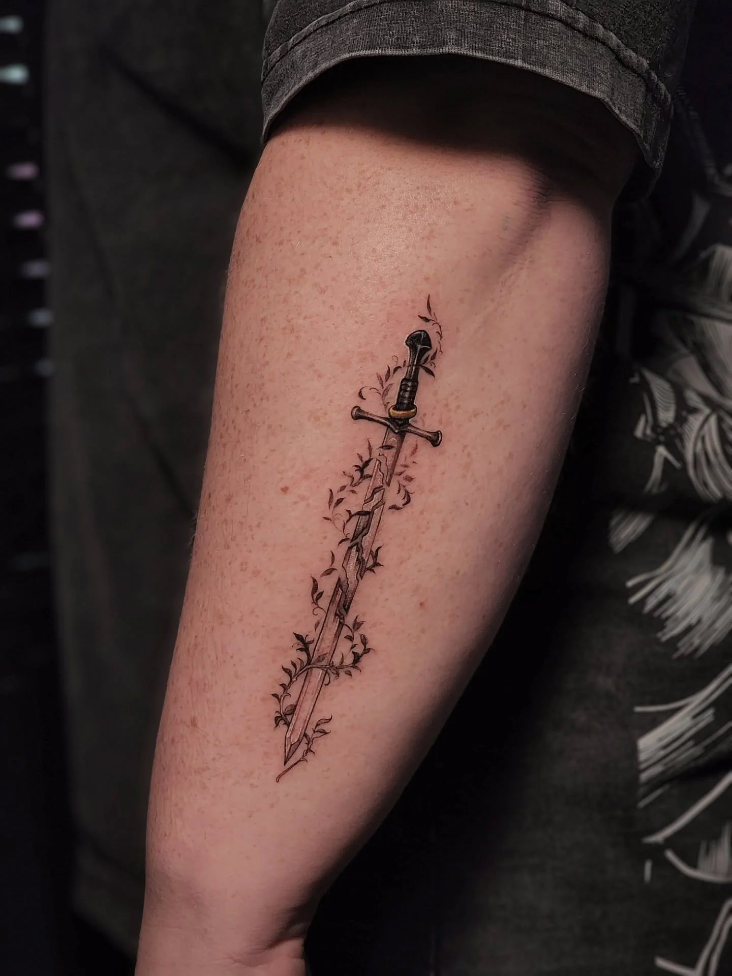 ✧ N A R S I L ✧

It was such a joy for me to tattoo this entwined Narsil Sword for Abby. Getting to create a combination of delicate fineline floral whimsy with the impactful nature of this Sword was such a cool project for my day :) 
Honestly, anyth