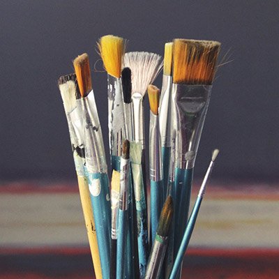 Et glas fyldt med malerpensler til kustneren der mangler inspiration