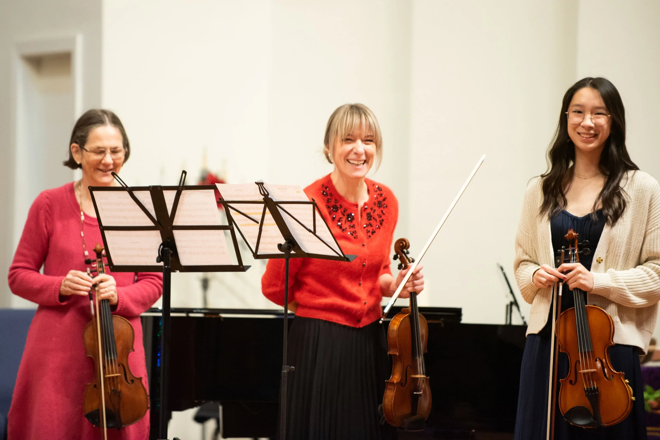 Carmen and students laugh happily at a violin recital
