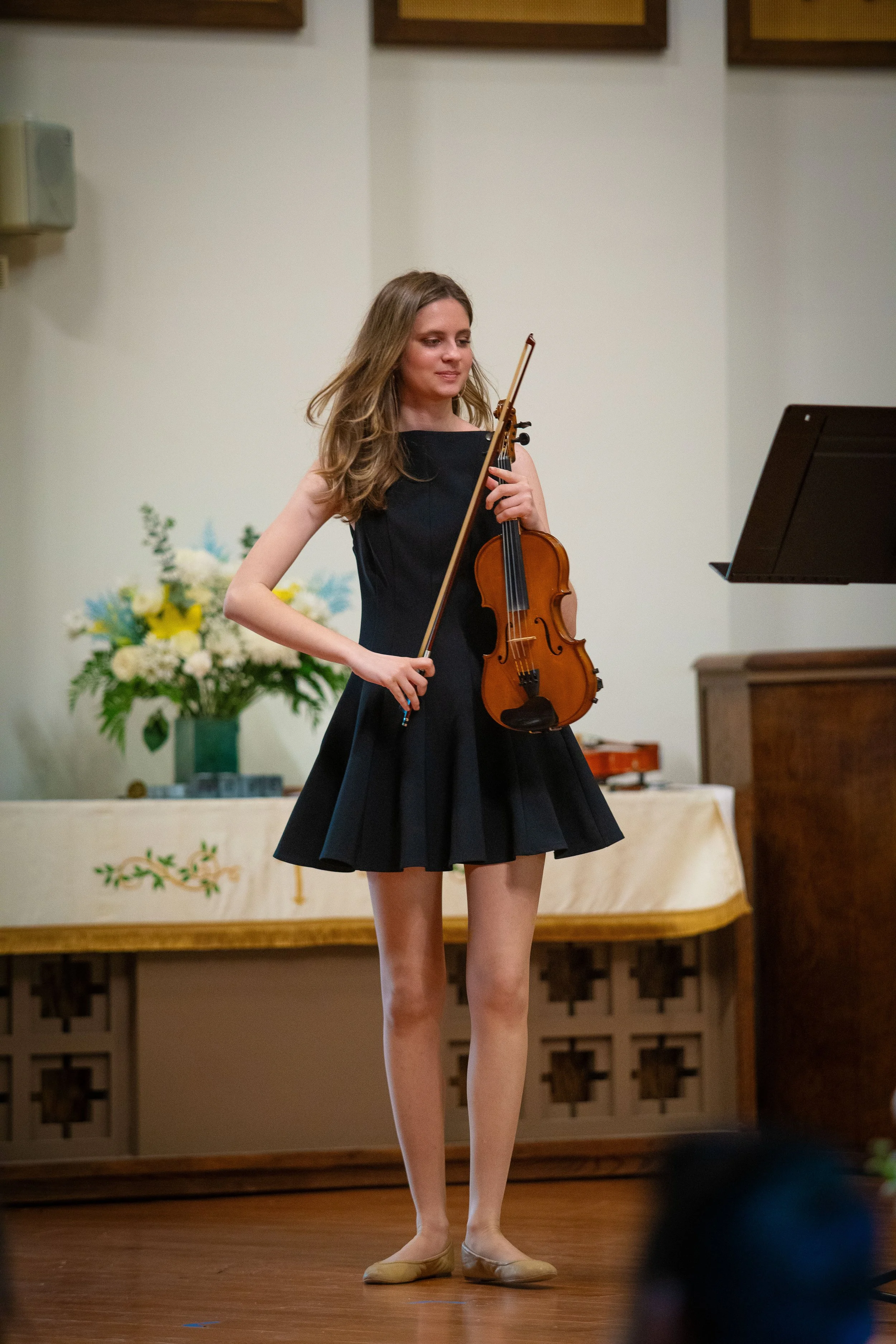 A teenage violin player proudly gets ready to play at a recital performance