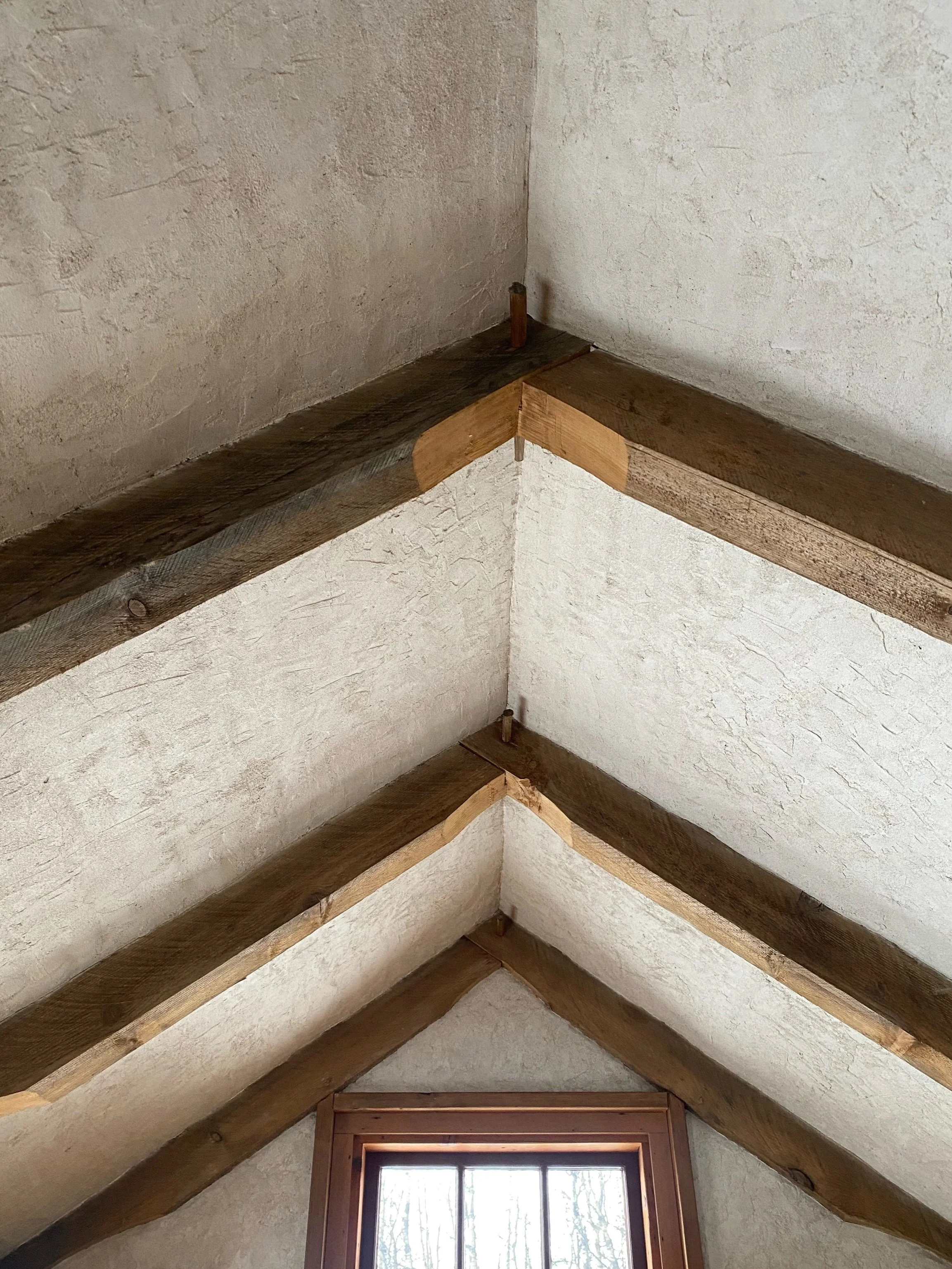 Ceiling detail from the cottage; exposed timber frame with lime plaster, 2024. 