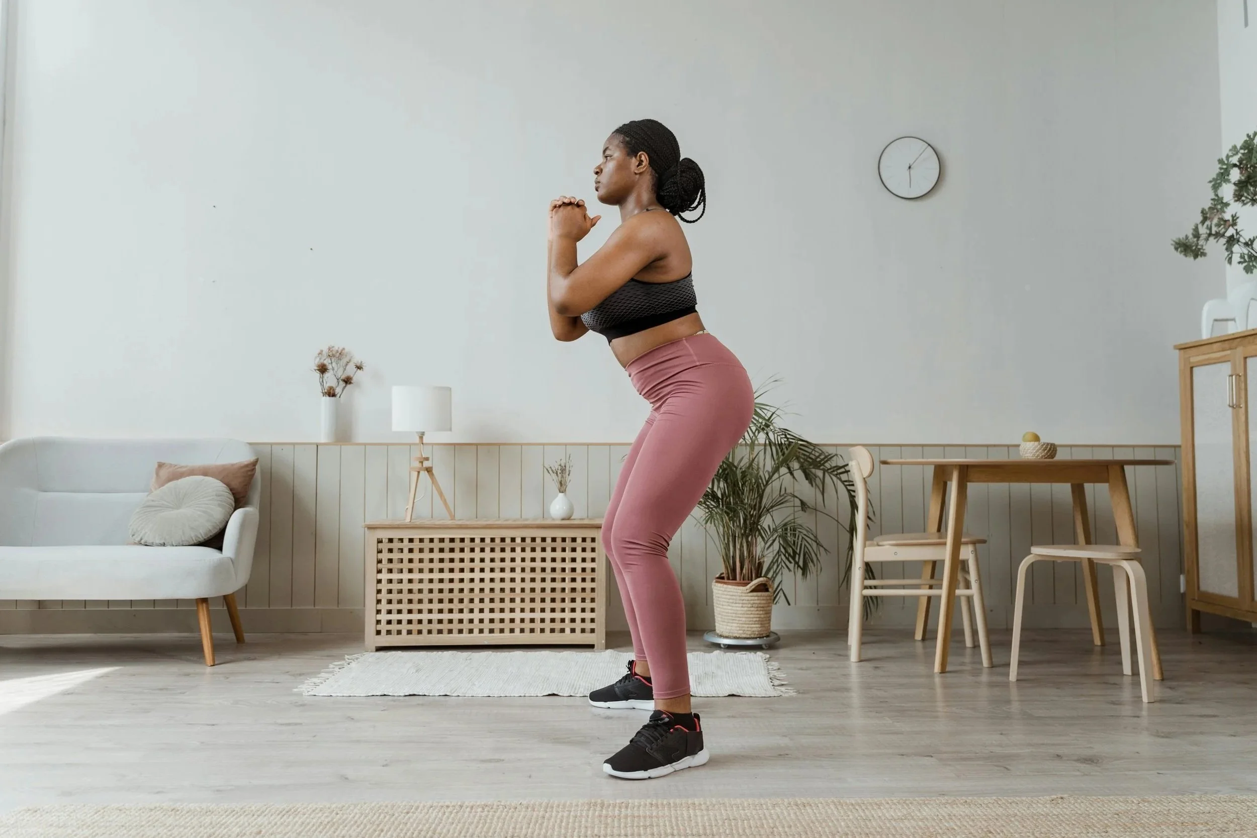 Woman engaging in trauma-informed movement at home, rebuilding trust with her body