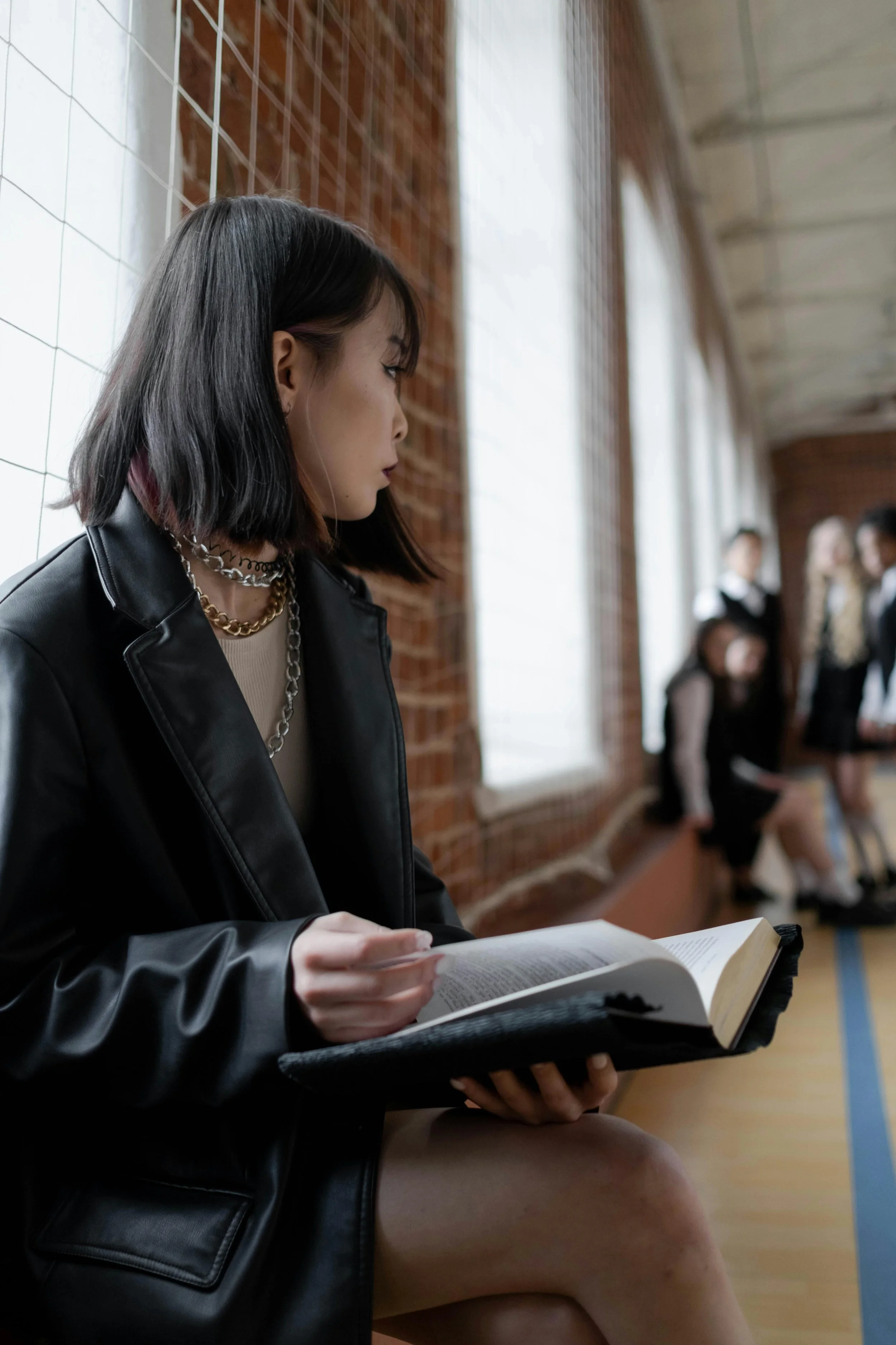 A young woman stands in a school hallway, glancing back at a group of people—capturing the tension of social pressure, self-doubt, and the desire to break free from people-pleasing patterns.