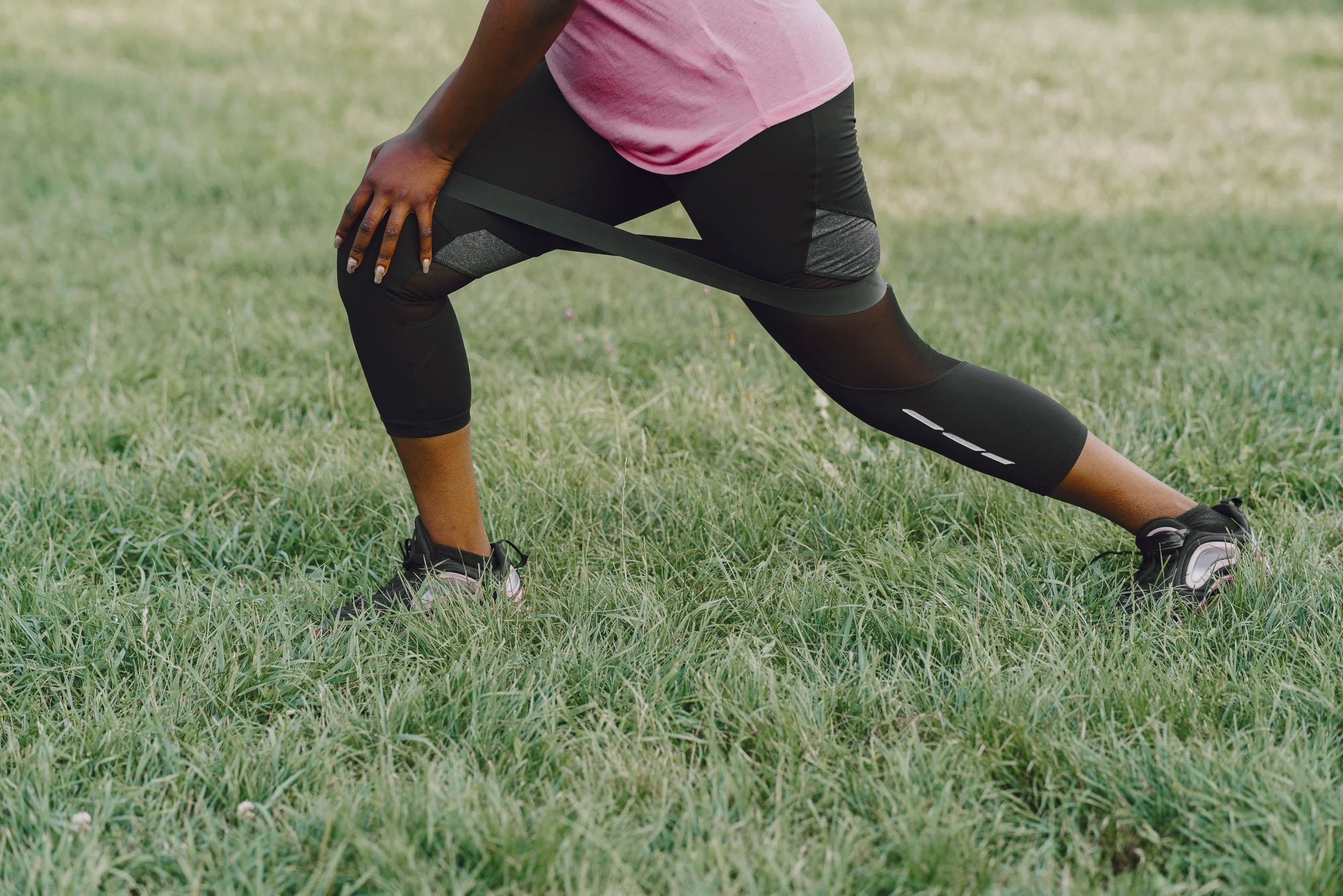 Woman doing resistance band training at home representing muscle preservation during GLP-1 therapy with a trauma-informed personal trainer