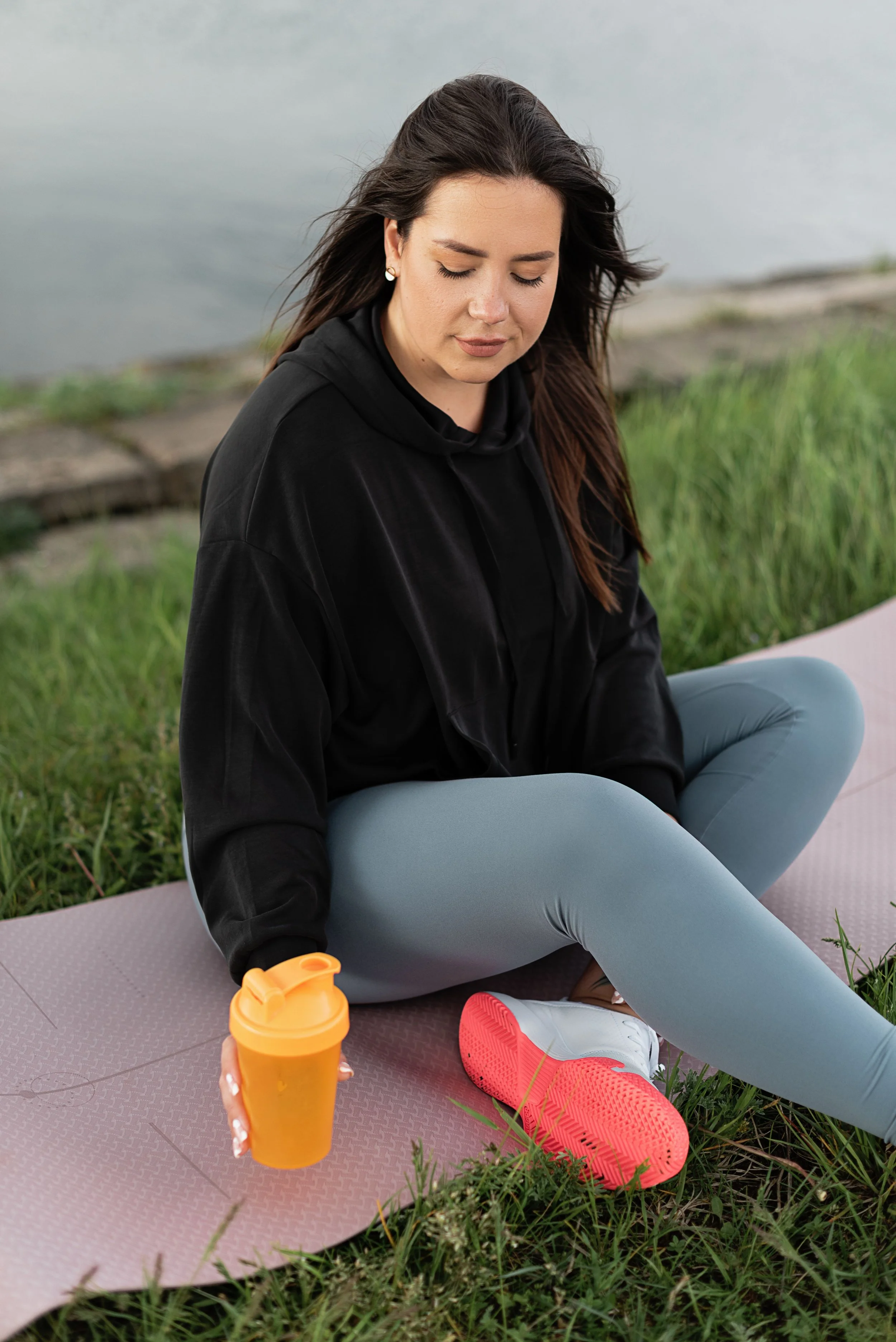 Woman sitting on yoga mat looking depleted representing how high-functioning anxiety affects exercise and the nervous system