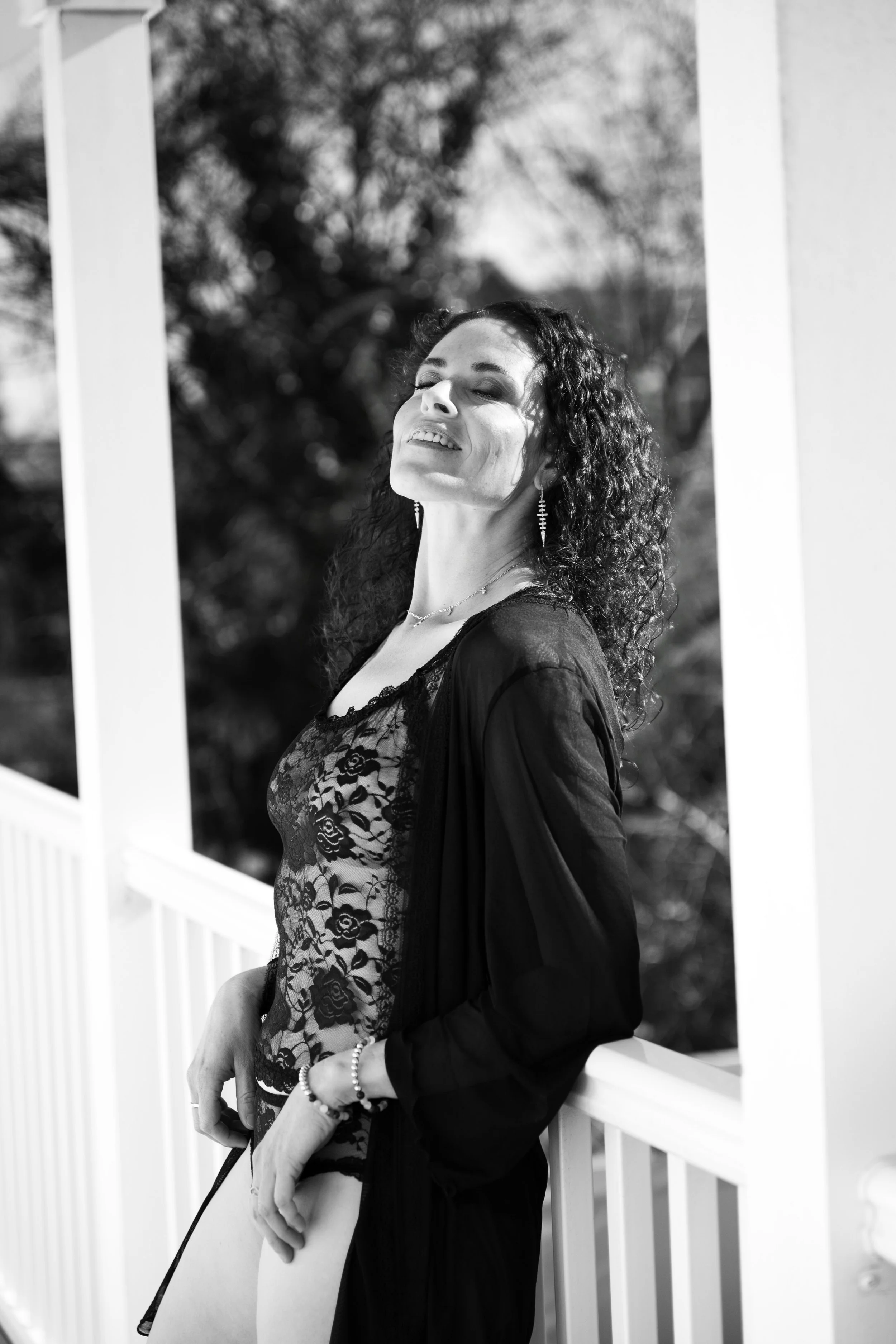 Woman standing outside in lingerie, light wrapping around her as she owns every inch of herself. 