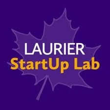 Graphic with purple background and a darker purple maple leaf outline. Text reads 'LAURIER StartUp Lab' with 'LAURIER' in white and 'StartUp Lab' in orange.