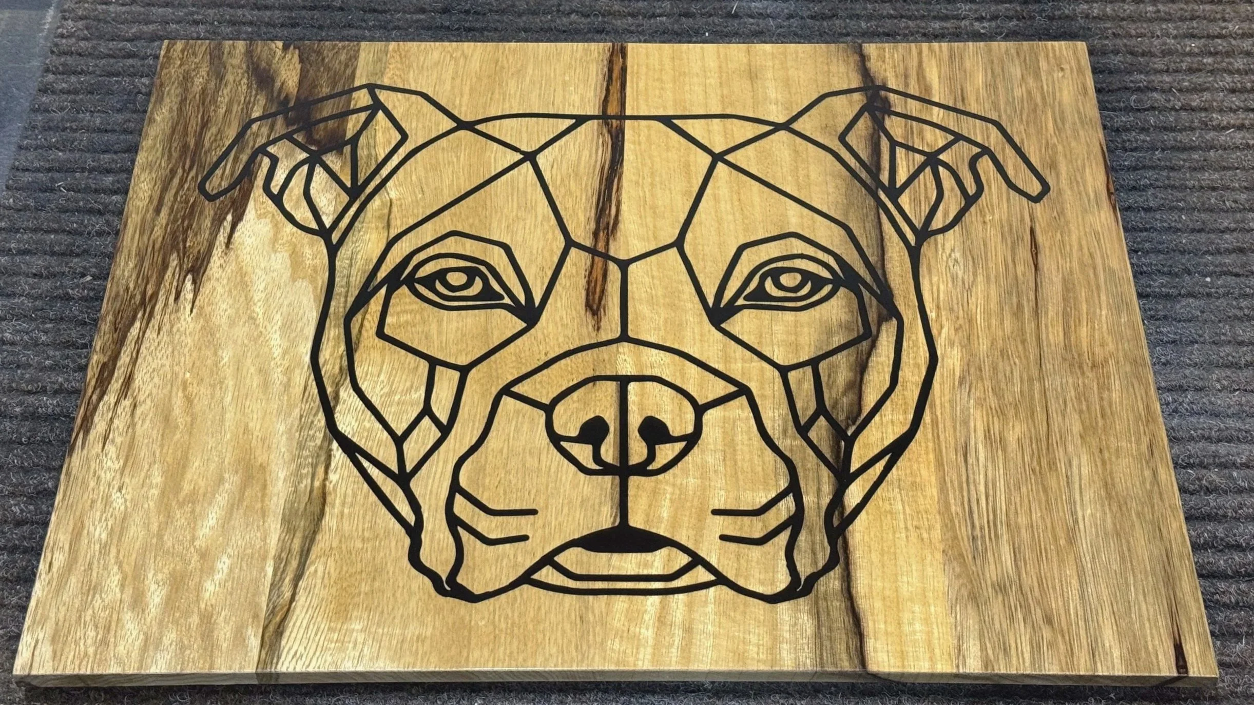 Wandobject van hout en epoxy. Inlay; uitsnede Staffie kop, opgevuld met zwarte epoxy