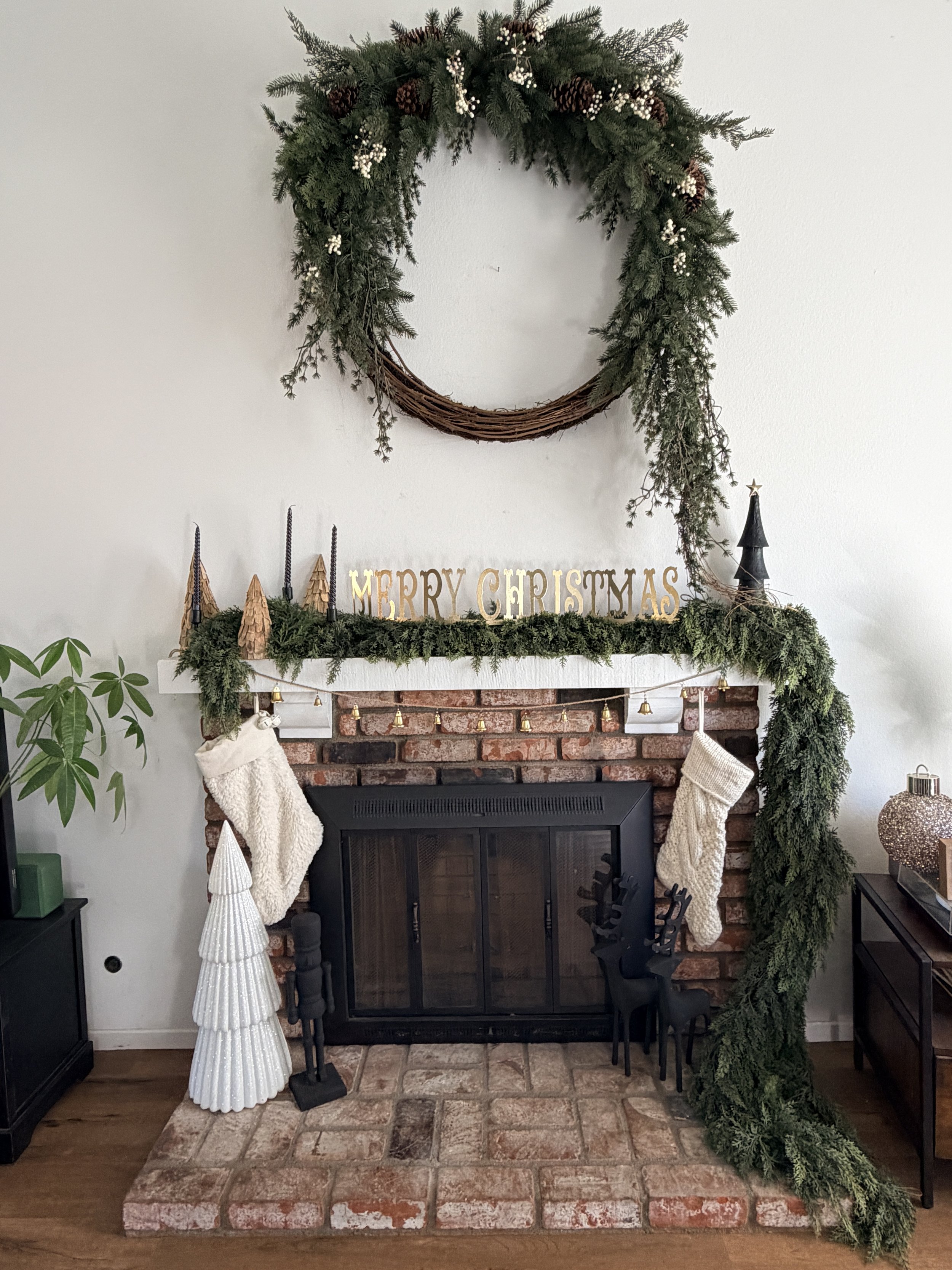 Decorated fireplace with Christmas wreath, garland, stockings, and holiday ornaments.