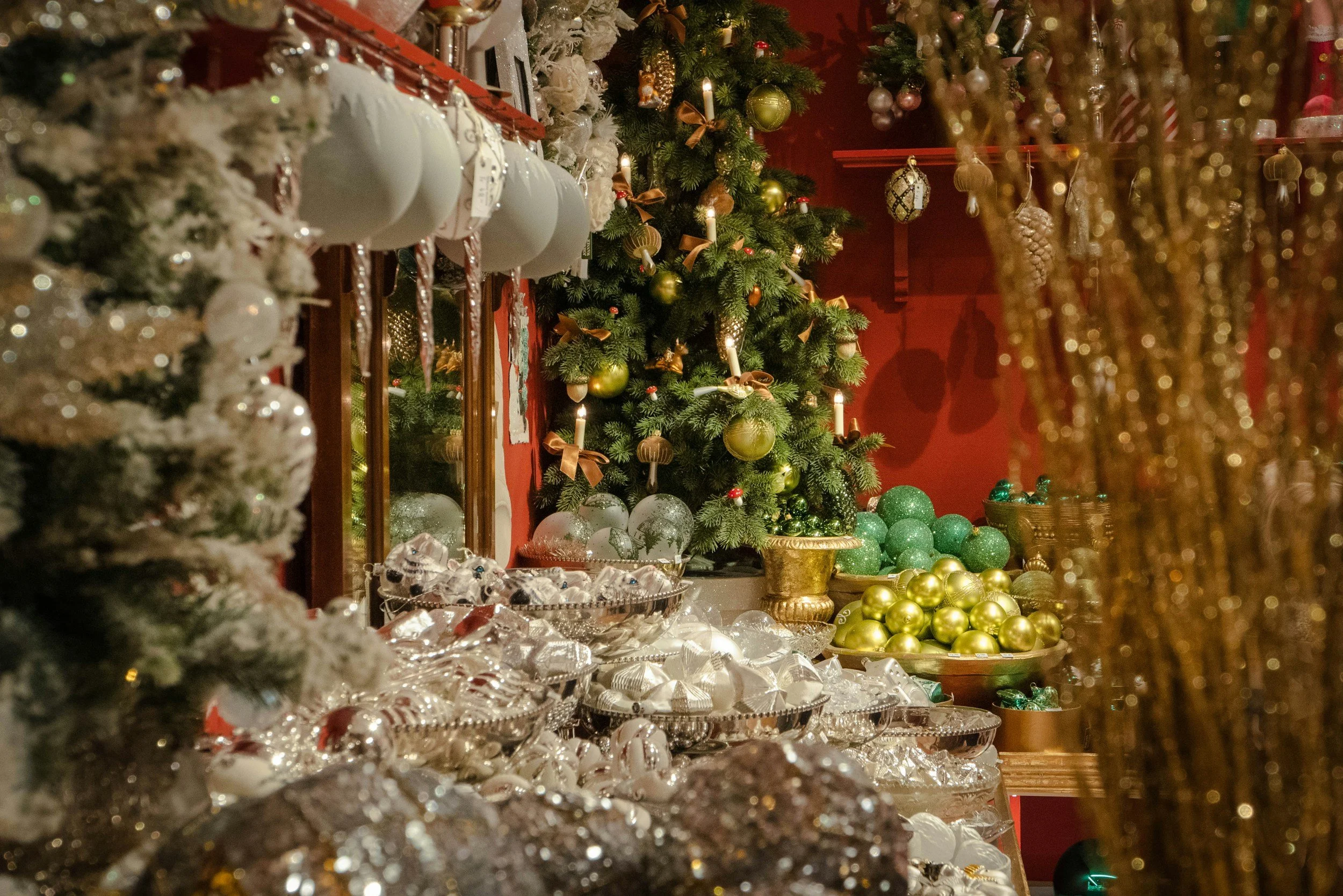 A Christmas display featuring a decorated Christmas tree, various ornaments, and decorations in gold, green, and white colors.