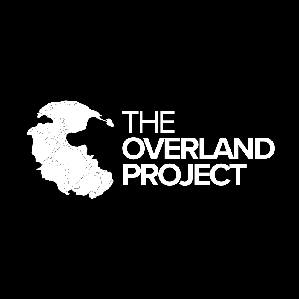 Black background with a white outline map of North and South America, labeled 'The Overland Project' in white text.