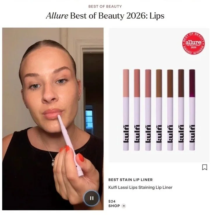 A woman applying Kulfi Lassi Lips Staining Lip Liner with a light pink lip liner, with other shades in a display next to her, from the Allure Best of Beauty 2026 awards.
