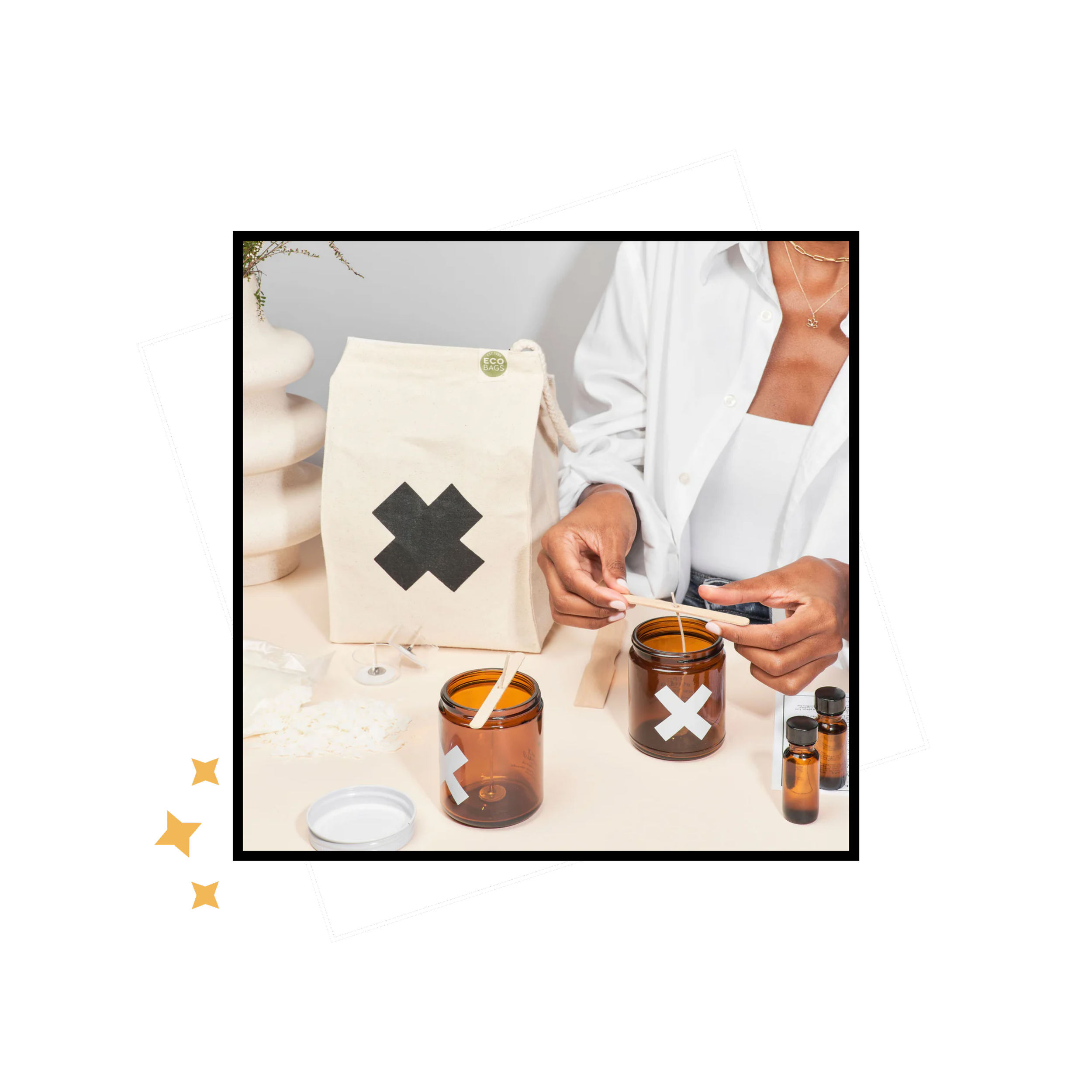 Hands working with Wax Buffalo amber jars, small oil bottles and a canvas bag marked with an X.