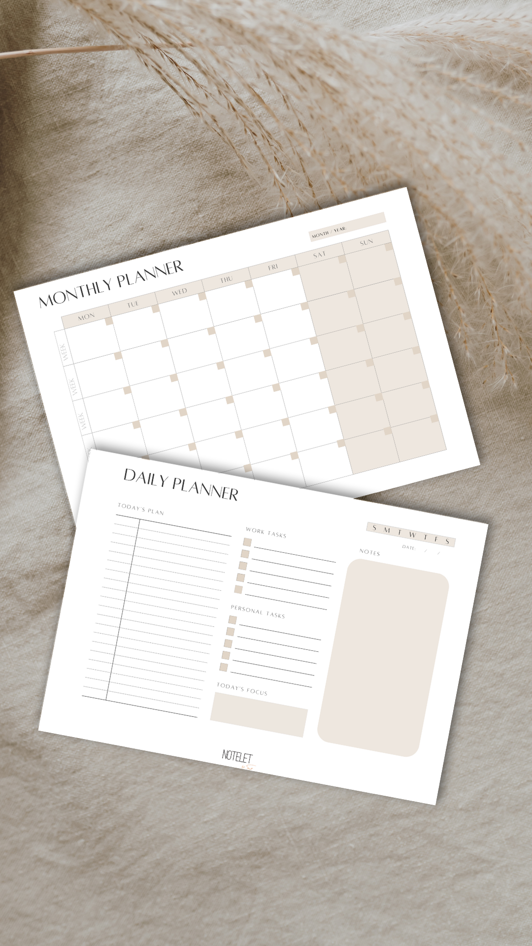 A blank monthly planner and a daily planner on a beige fabric surface, with decorative dried grass.