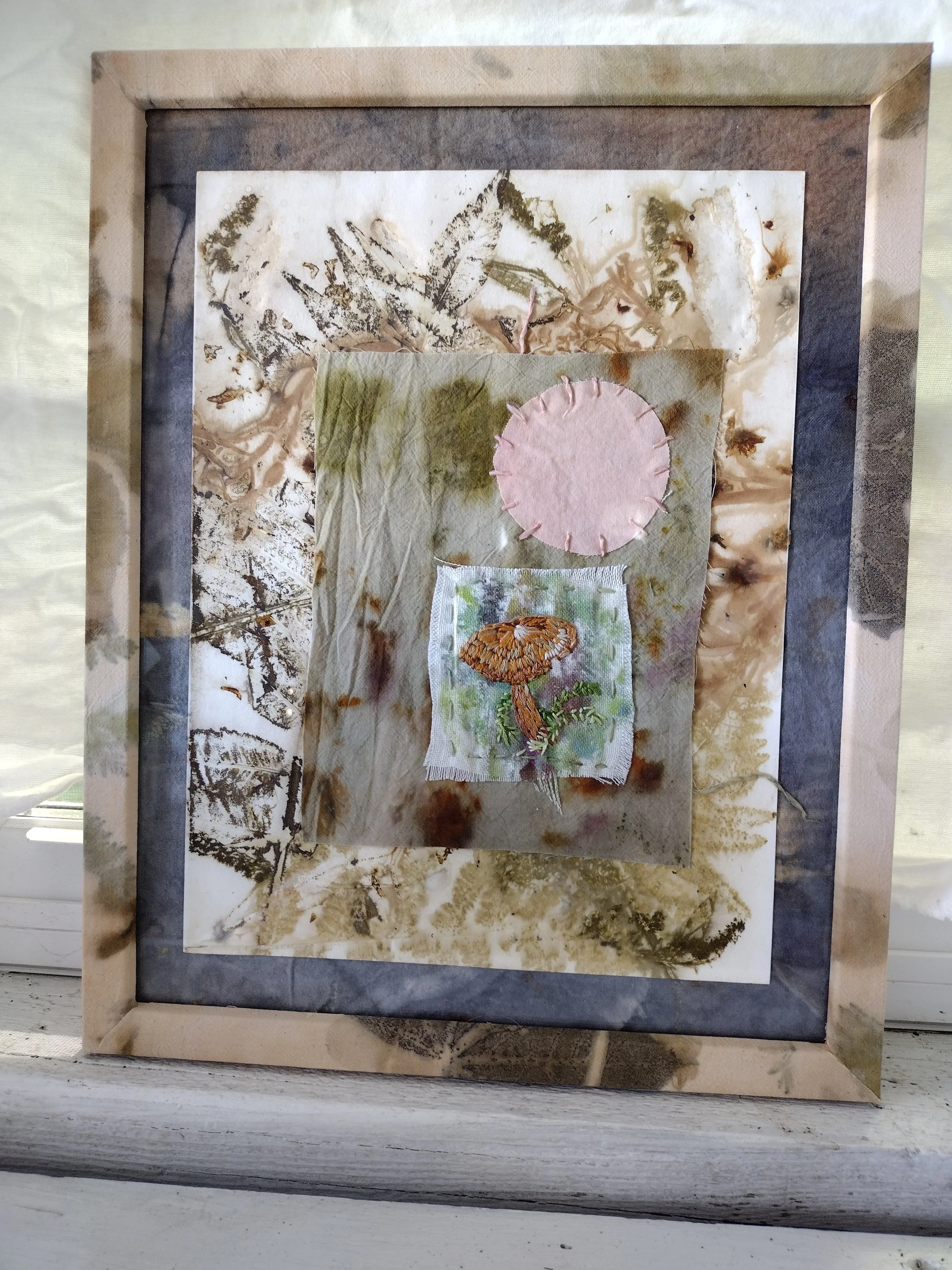 Mixed media artwork featuring a textured background with botanical and mushroom depictions, framed with a layered border. By Amy Real