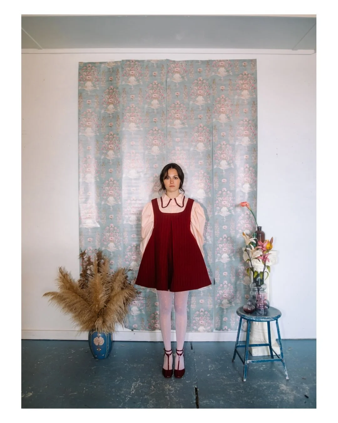 FEYA
Designed and created by: @abbeygracetuck 

This look features a wool A-line pinafore dress in a deep red and burgundy stripe, layered over a soft peach cotton blouse.

The blouse is designed with a rounded collar finished with contrast burgundy 